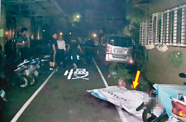 遭兒子瘋狂砍殺百餘刀的陳父(箭頭處),最後滿身是血,倒臥路邊。(翻攝畫面)