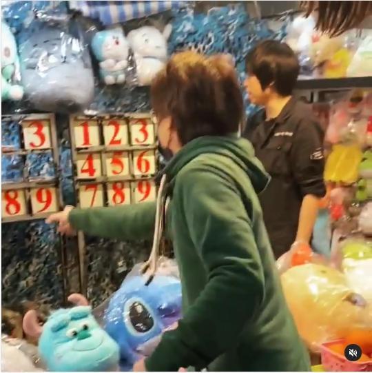 HowHow在士林夜市玩棒球九宮格,老闆側臉超像五月天阿信。(翻攝自howhowhasfriends Instagram)