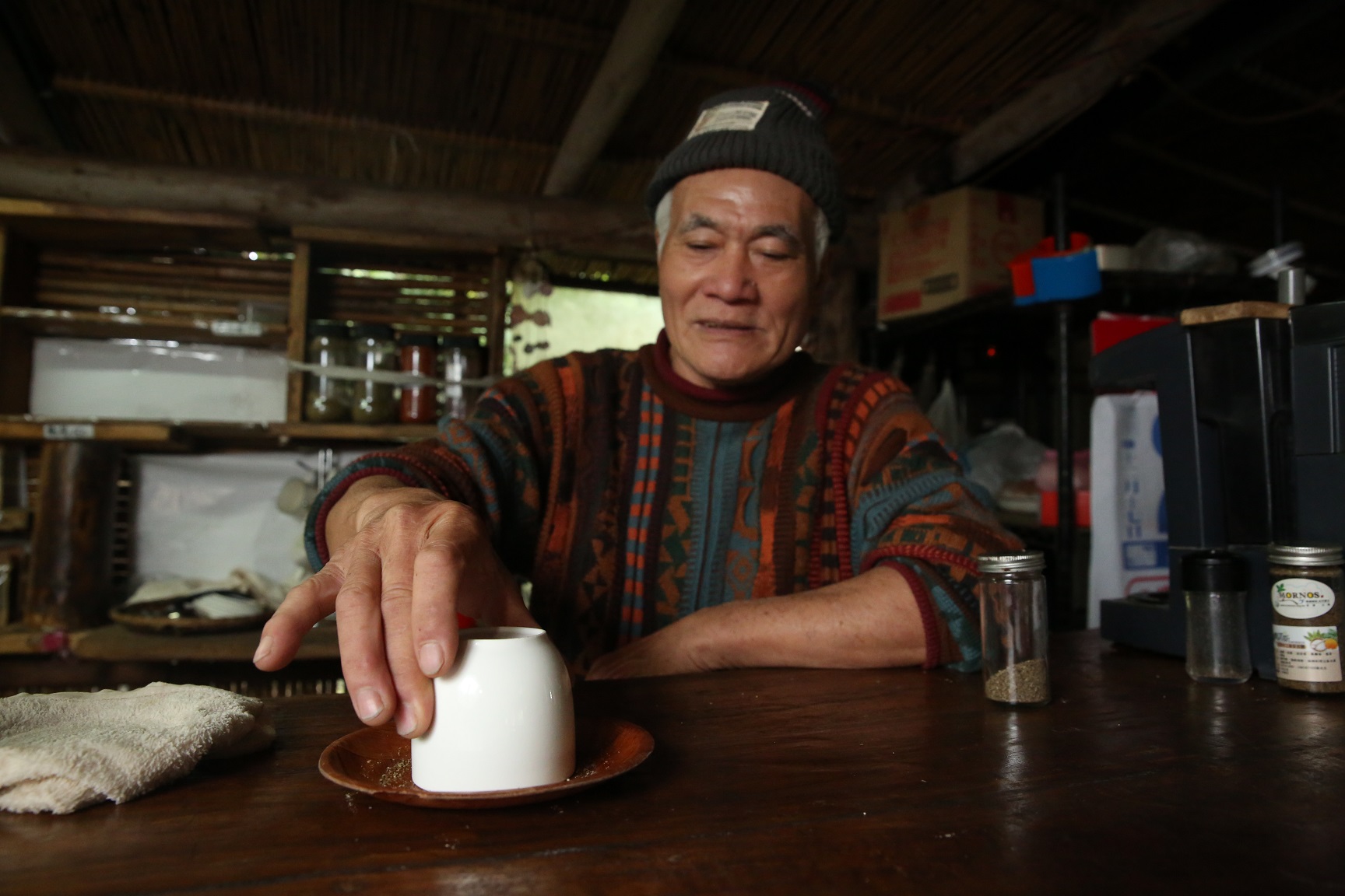 蔡爺爺倒扣杯子，在杯口抹上他的海鹽。