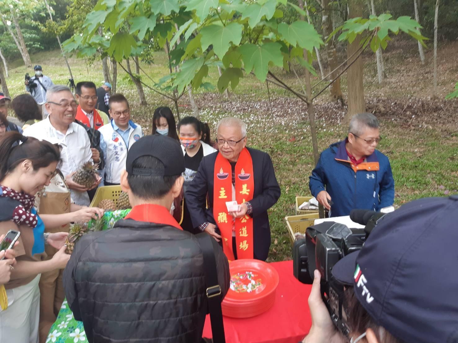 劉泰英響應姜太公道場愛農計畫於客家大院叫賣鳳梨,遊客反應熱烈,上百顆鳳梨被搶購一空。(姜太公道場提供)