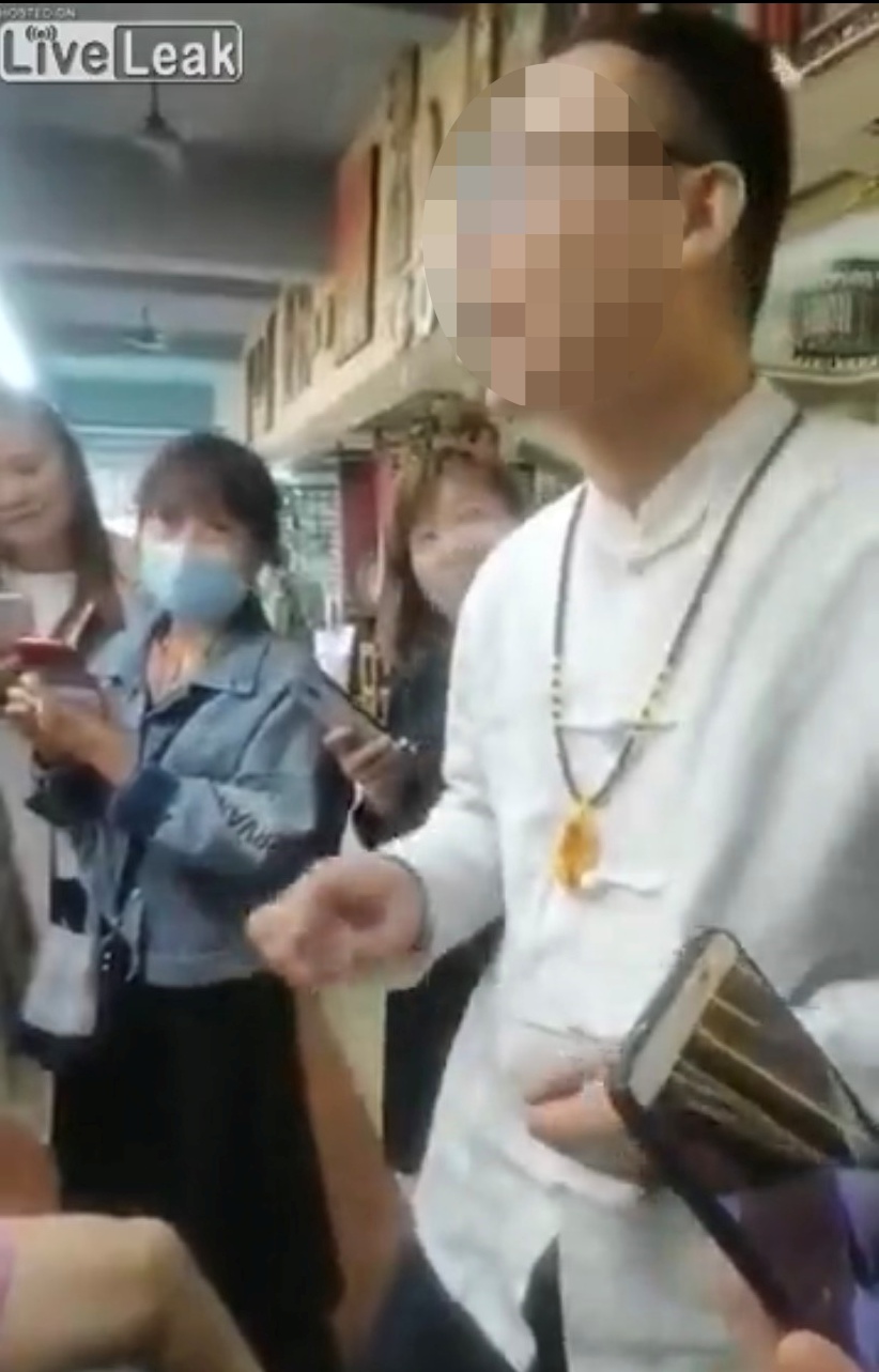 自稱是「專家」的師傅,在療程開始前與圍觀的婦女們閒聊。(翻攝自Liveleak)