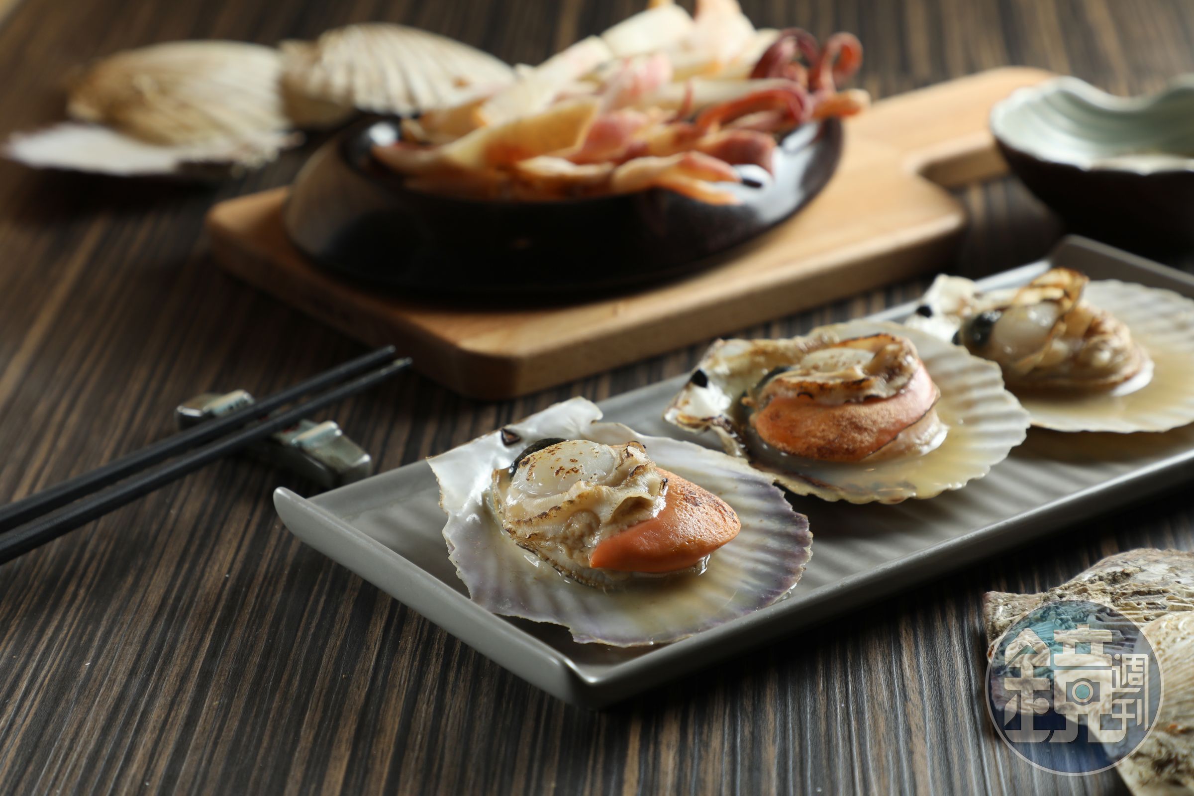 北海道的「烤扇貝」（前，160元／份）多汁嫩甜；「烤魷魚」（後，240元／份）蘸上蠟味美乃滋頗涮嘴。