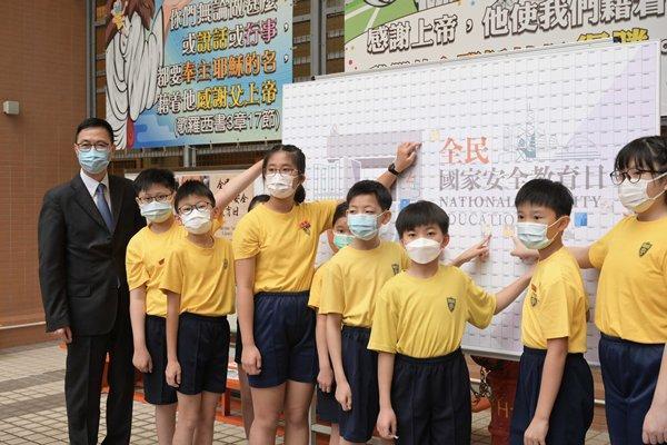 《港版國安法》通過後，香港舉行首次「全民國家安全教育日」，學生被要求唱中國國歌、升中國國旗。（翻攝香港政府新聞網）