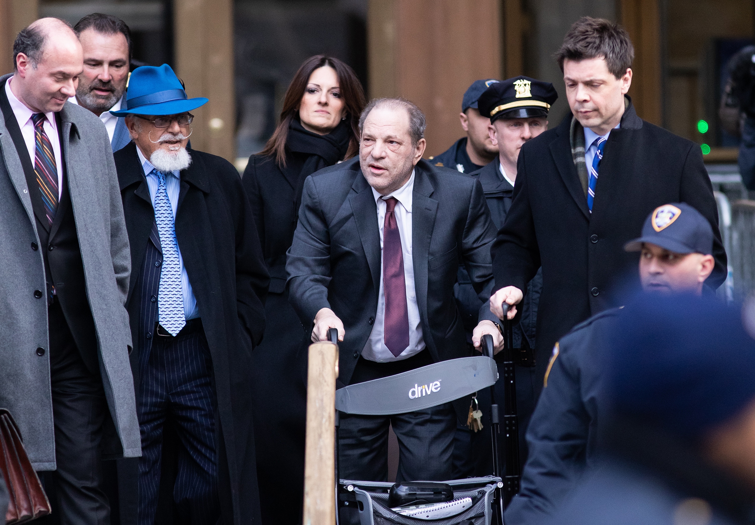 好萊塢淫魔製片哈維韋恩斯坦（中）去年出庭時就已使用輪椅方能輔助行走，入獄後其律師更宣稱他一隻眼近乎失明，還掉了4顆牙。（東方IC）