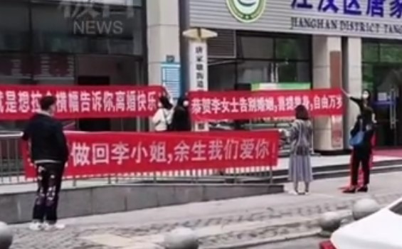 大陸1對年輕夫婦前往民政局辦理離婚時，女方的朋友直接拉起紅布條慶祝。（翻攝自微博）