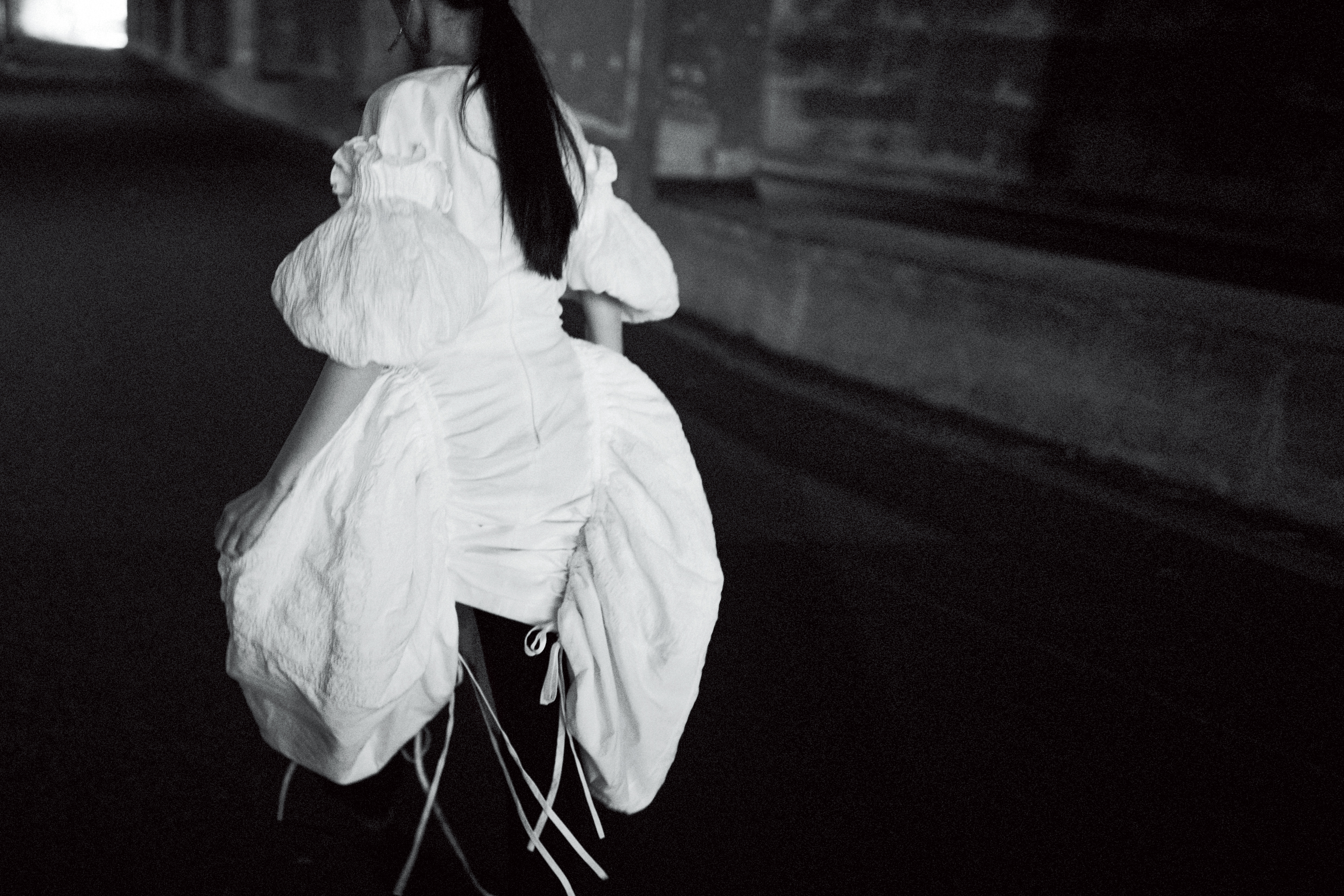 白色立體洋裝 NT$227,000 by LOEWE／黑色西裝褲 NT$43,500 by PRADA／三角Logo耳環 NT$19,000（單邊） by PRADA