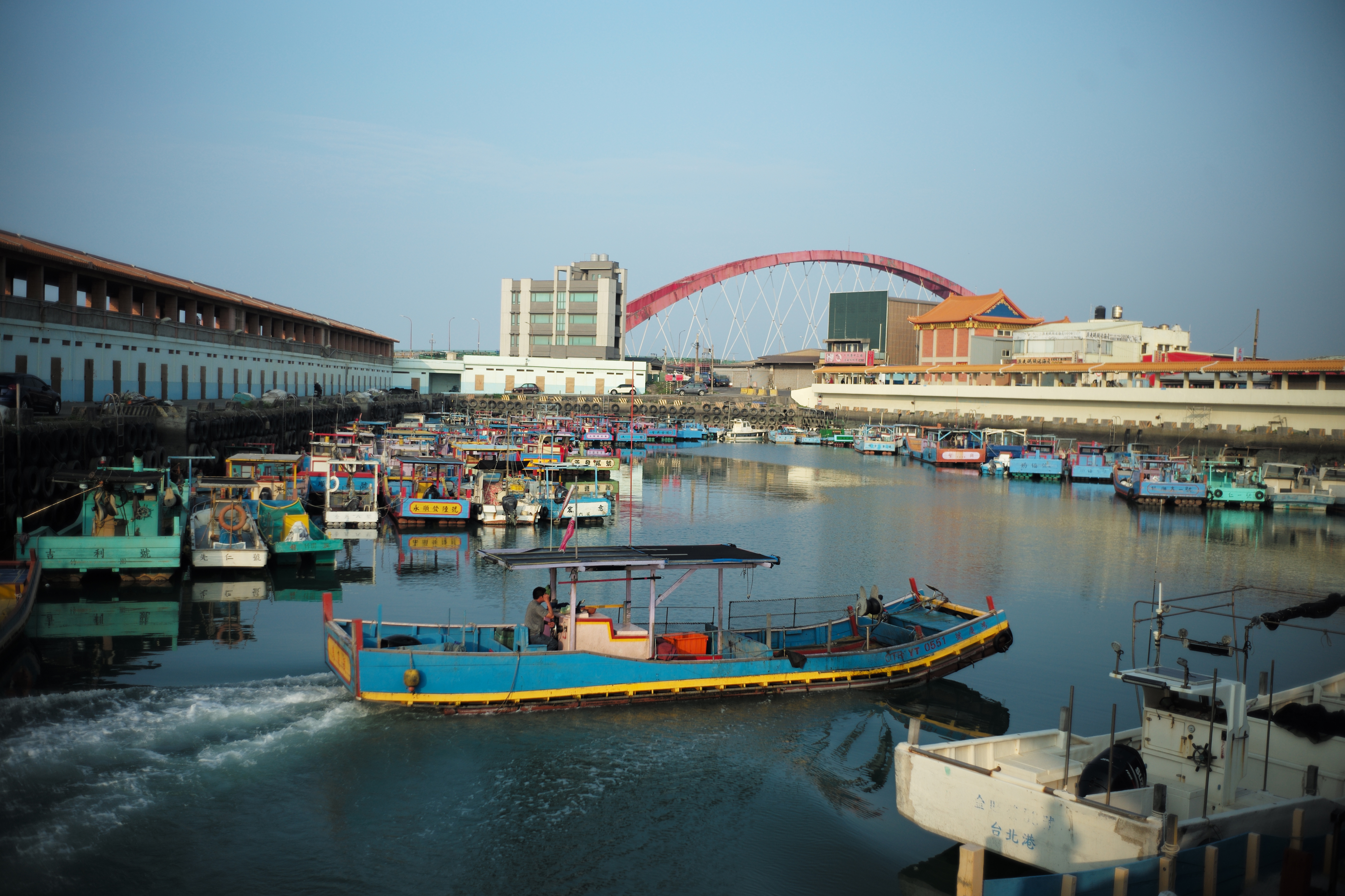 一艘小漁船在黃昏時緩緩駛進竹圍漁港。