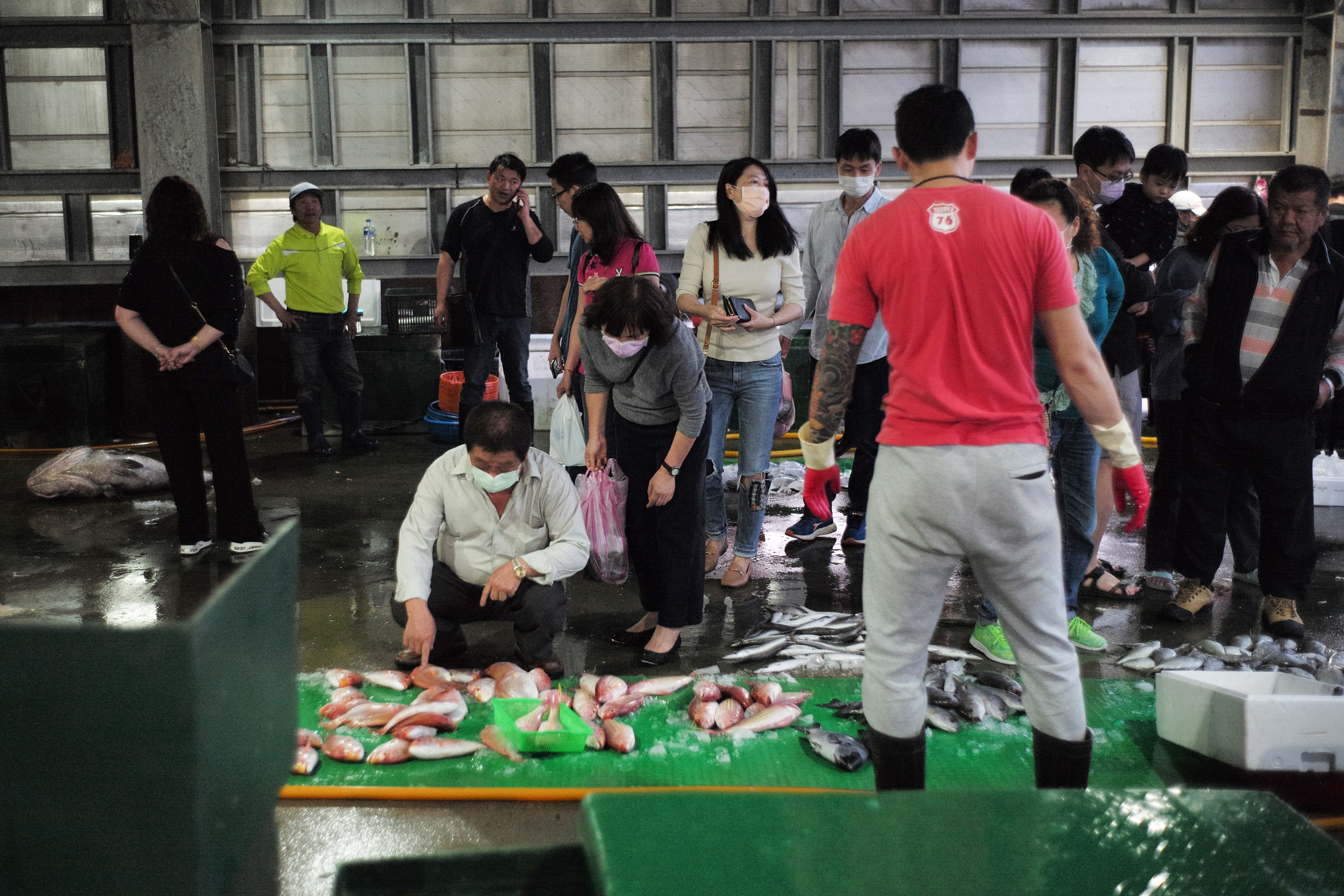 黃昏時的港口旁有許多剛捕撈上岸的魚供民眾挑選。