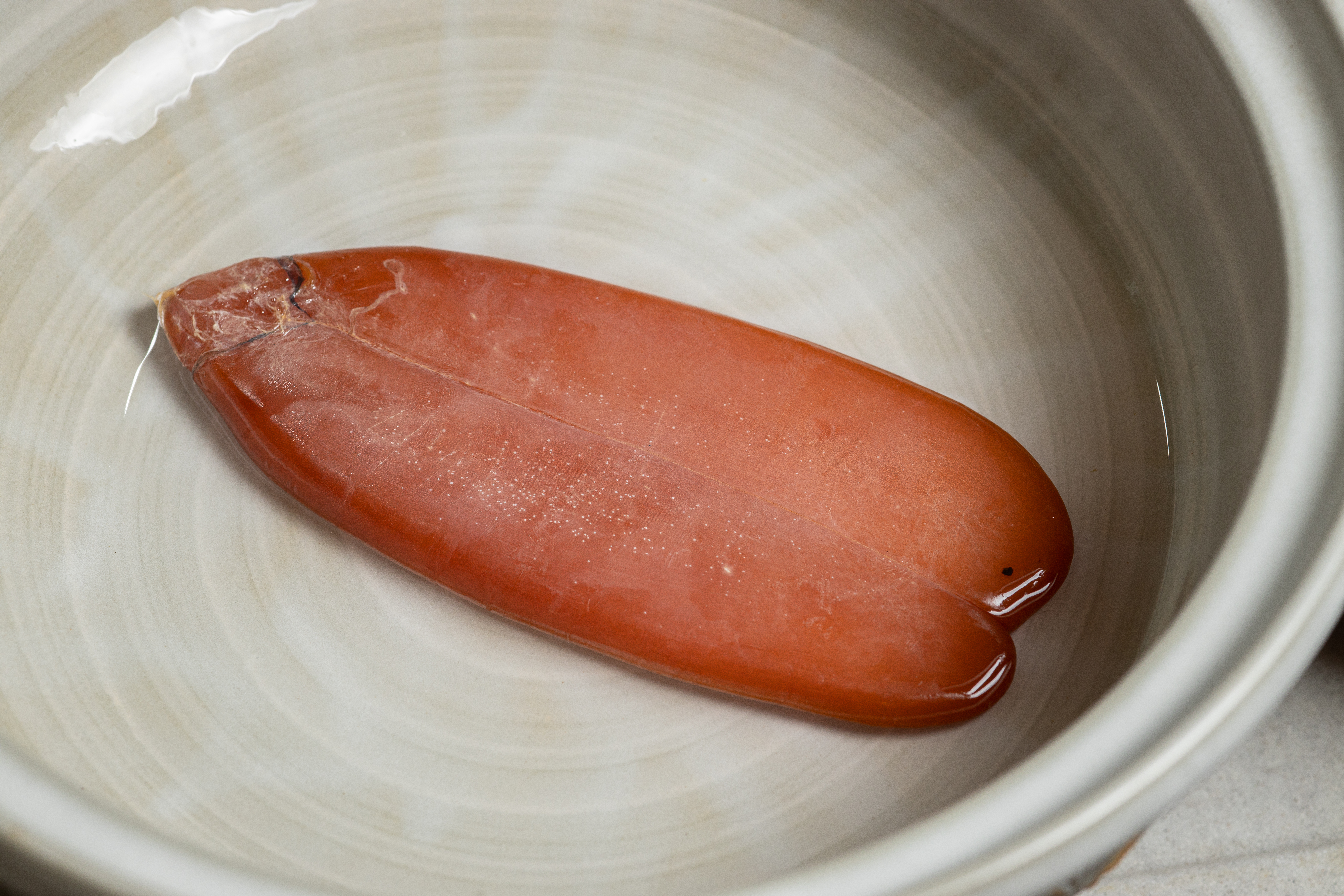在高粱中浸烏魚子約10分鐘，剝去外膜。