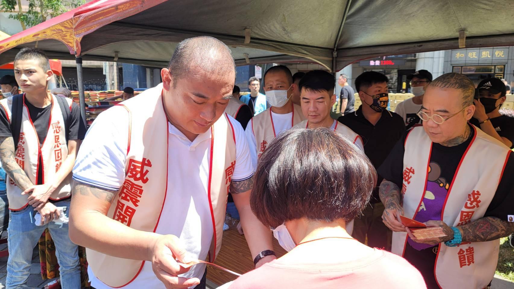威震愛心發展協會理事長吳明達發放愛心白米及600元的家樂福禮卷給大同區低收入戶。(讀者提供)