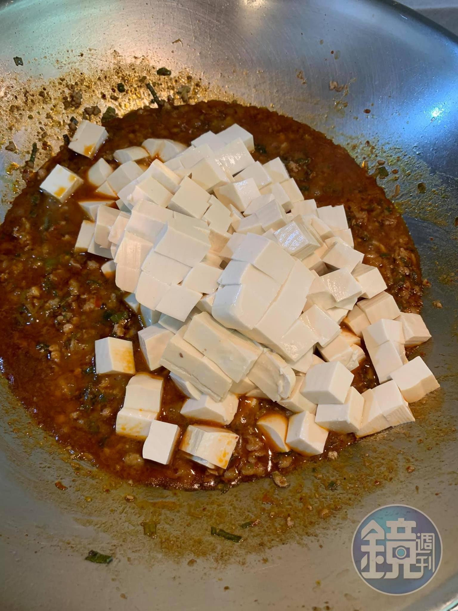 在醬汁中放入豆腐煨煮入味。