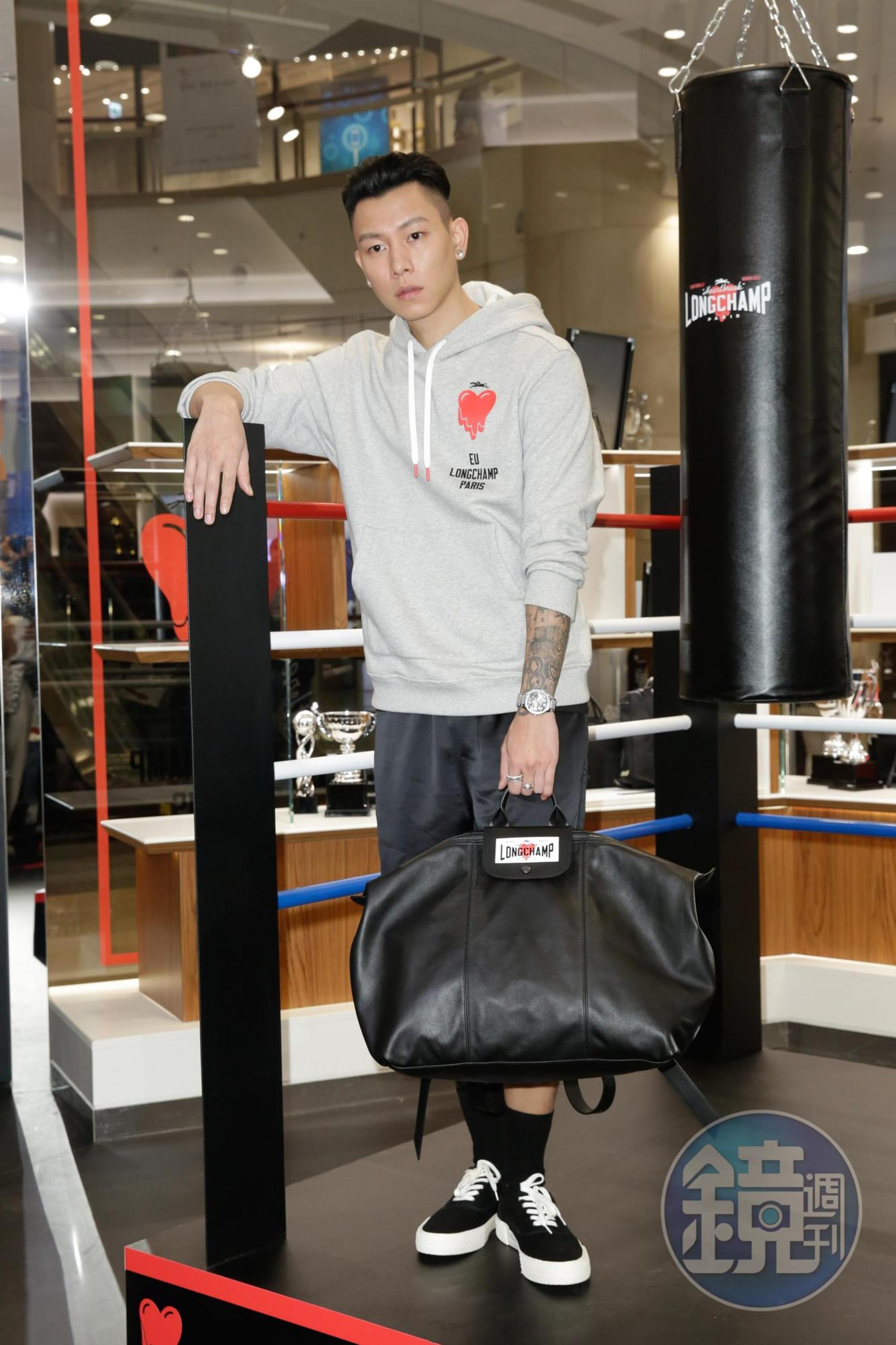瘦子身穿LONGCHAMP logo連帽衛衣NT$7,400、緞面短褲NT$9,100、可調節式手袋NT$34,100。