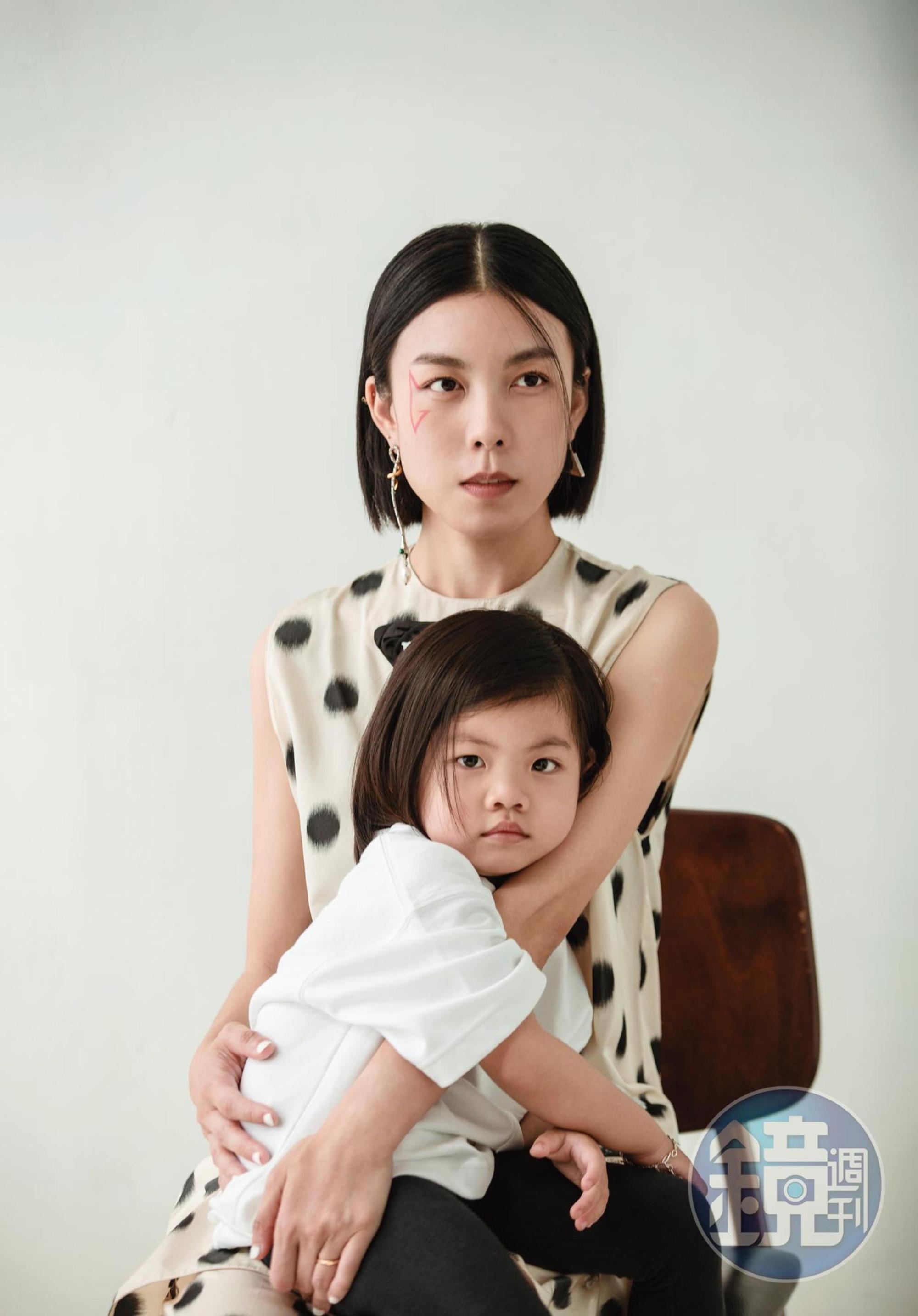 圓點無袖洋裝 NT$80,000 by PRADA／圓點直筒長褲 NT$84,000 by PRADA／（左）垂墜耳環 價格店洽 by Chloé／（右）三角Logo耳環 價格店洽 by PRADA