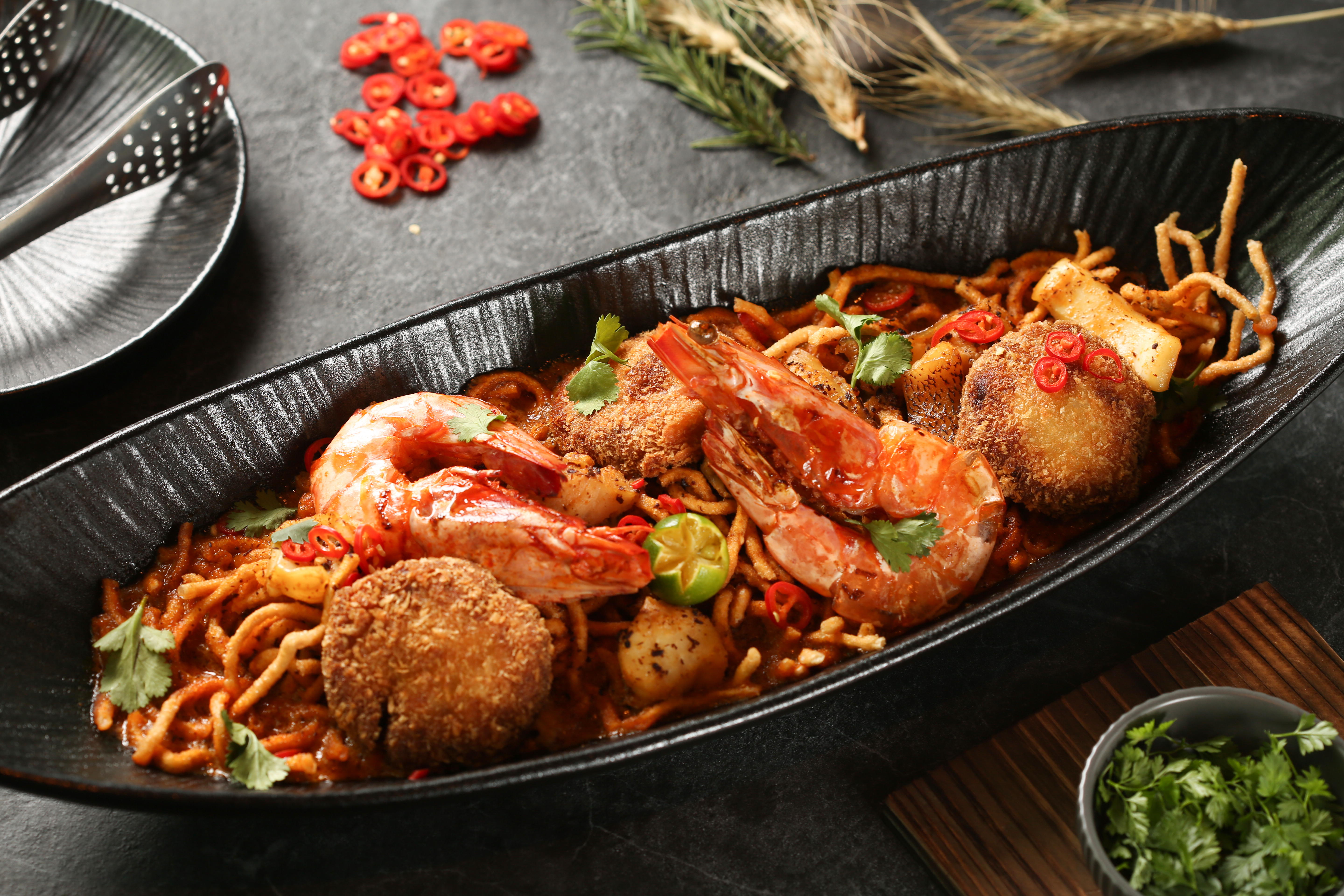 「叻沙海鮮撈麵」用油炸麵配上濃郁紅咖哩醬汁，從麵體到醬汁都異於傳統版本，是一道要用夾子「夾」起來吃的叻沙麵。（1,680元／份）