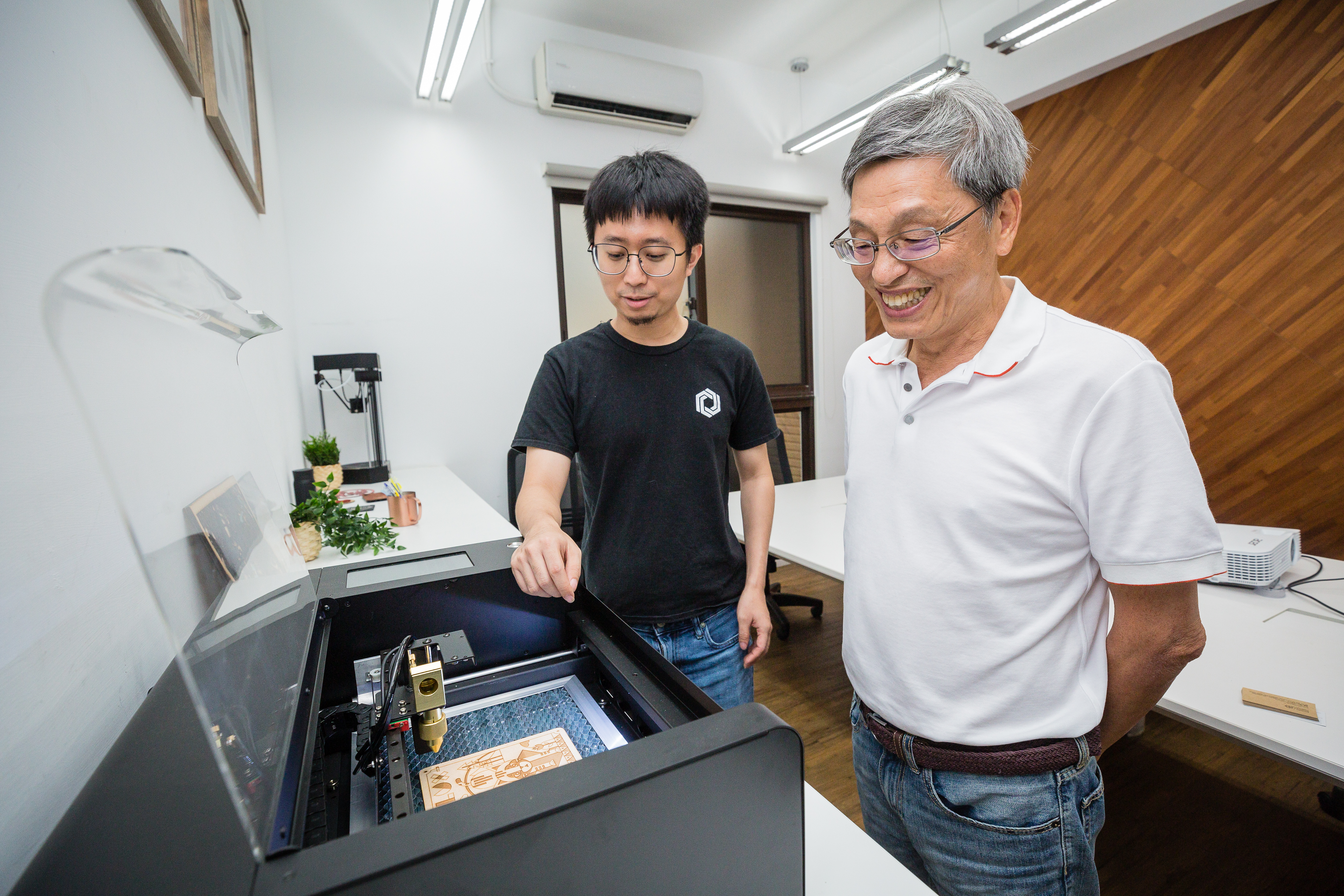 柯軒恩如今已能自信滿滿在陳五福（右）面前，展示銷售成績不錯的3D雷射切割機。