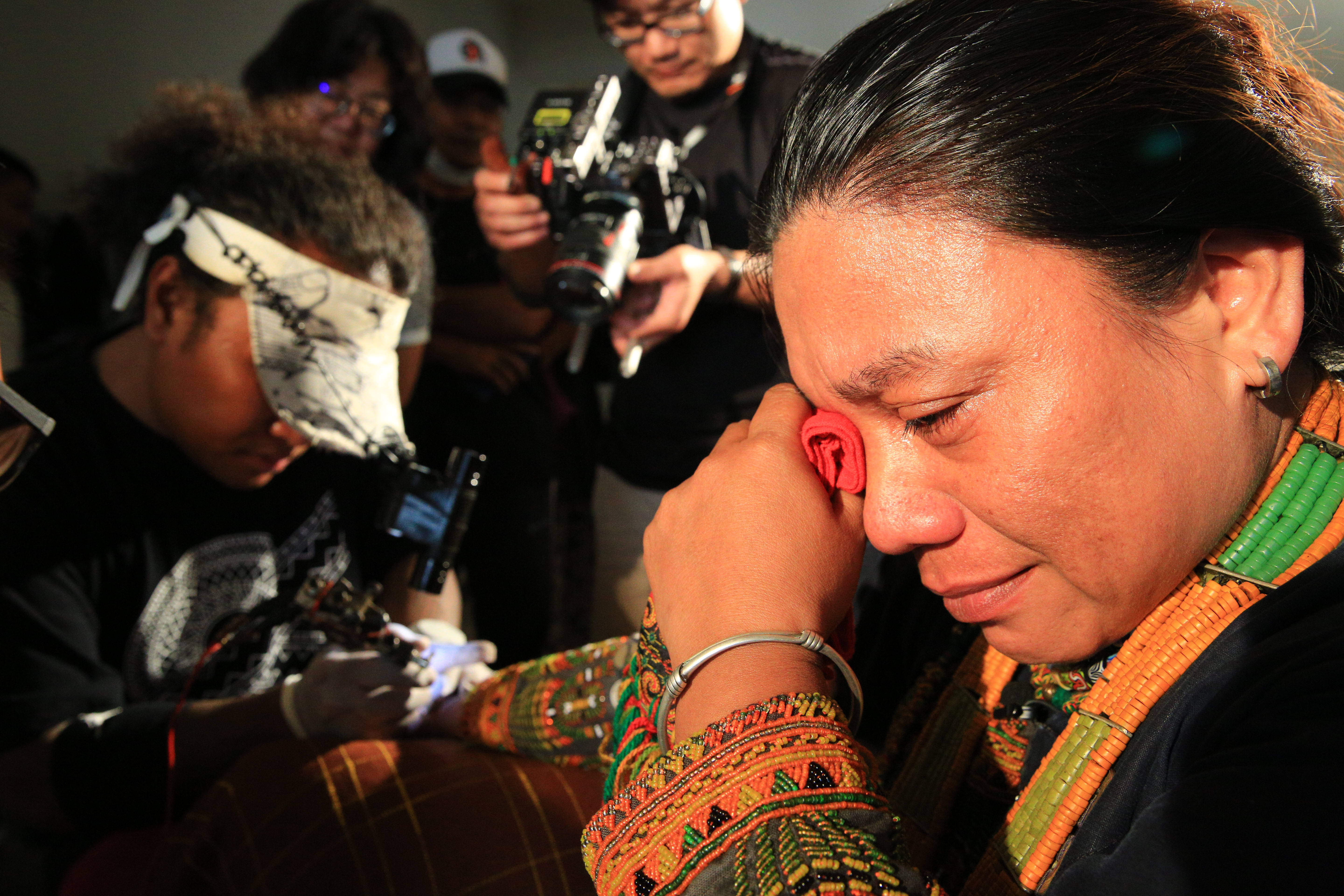 繼承頭目的廖莉華遵照排灣族習俗舉行紋手儀式，刀片來回刮開皮膚的痛楚讓她掉下眼淚。  （牽猴子整合行銷提供）