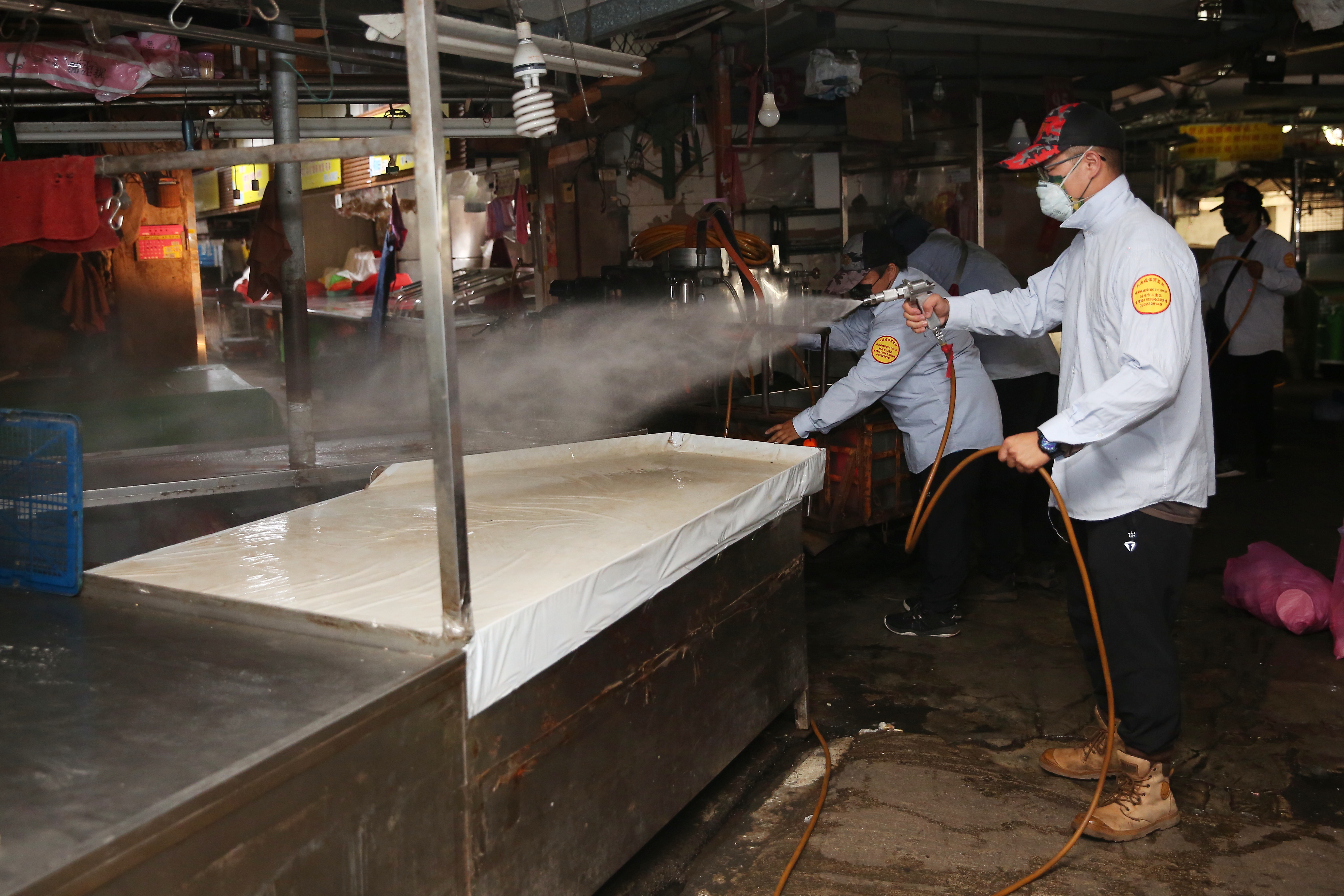 隨著國內疫情升溫，有假消息在仿間流傳。圖為新北市永安市場消毒。