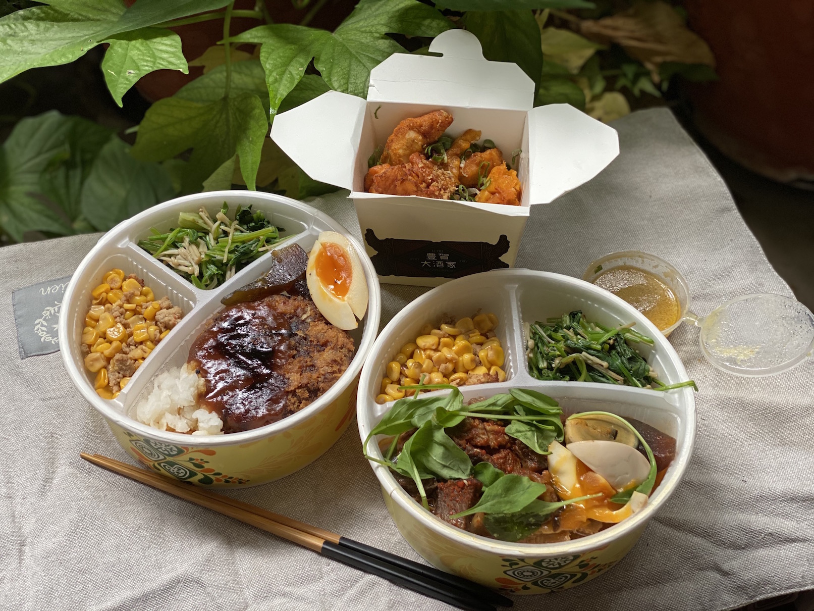 「豊賀大酒家」集合人氣招牌菜及各品牌聯名創作菜色推出外賣便當。（臭豆腐牛漢堡排、味噌牛五臟便當各320元 ／ 份，蛋黃鹹酥雞180元 ／ 份）