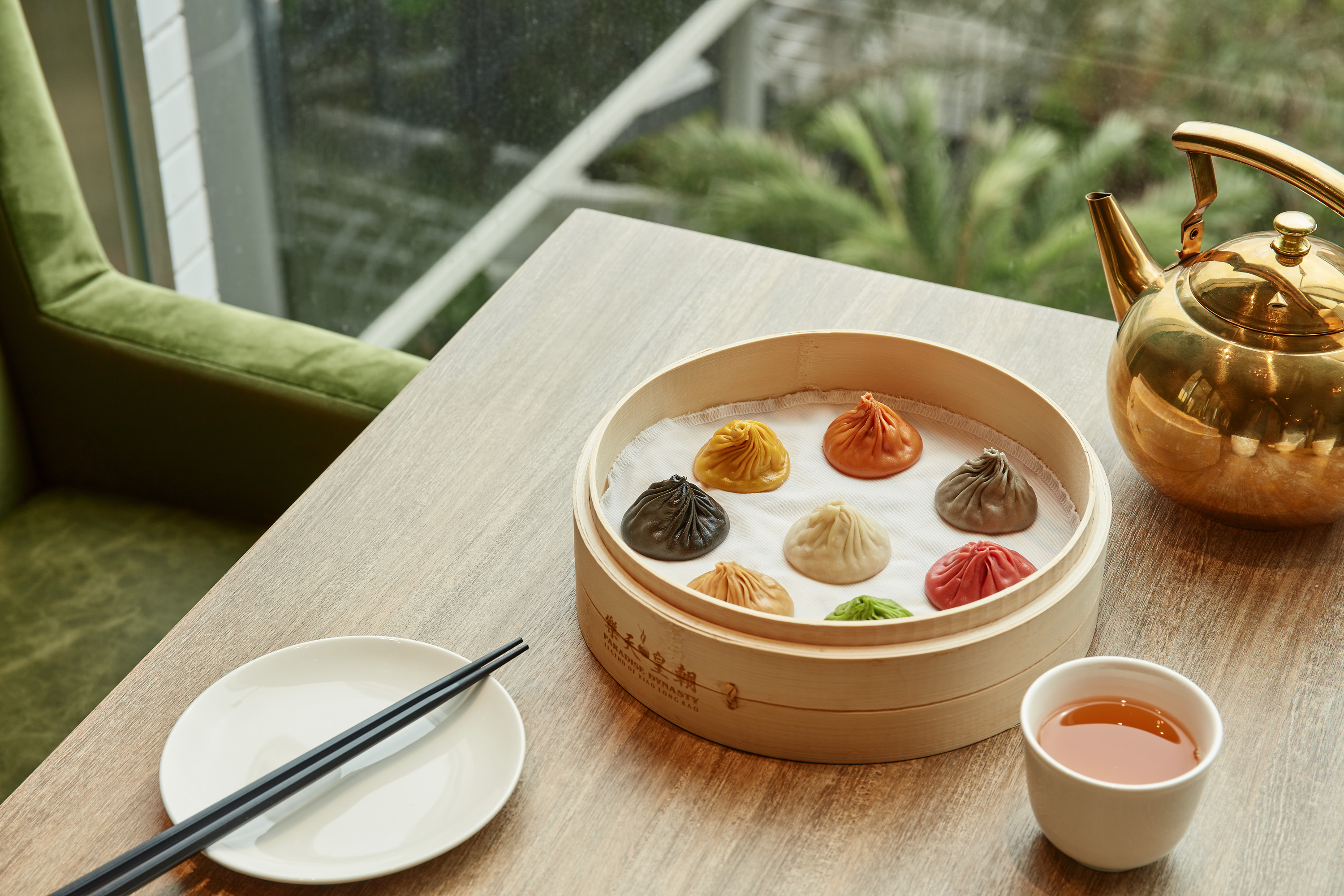 中餐廳「樂天皇朝」的「八色小籠包」，有原味、人蔘、鵝肝、黑松露、起司、蟹粉、蒜香和川味共8款口味，顏色繽紛，上桌吸睛。（台灣樂天餐飲集團提供）