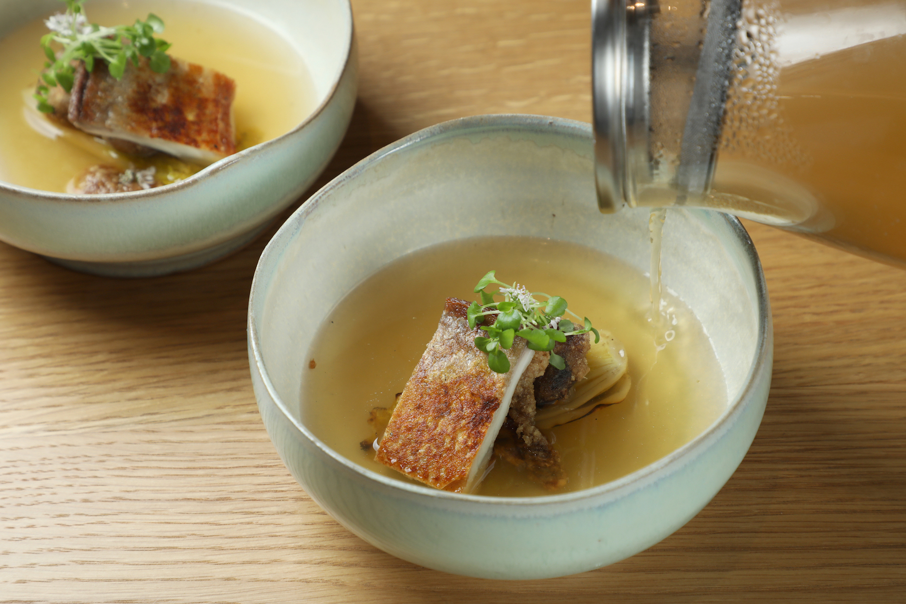 「虱目魚 娃娃菜」將虱目魚肚煎到魚皮如餅乾薄脆，裹薄粉油炸虱目魚腸，淋上以大量高麗菜、扁魚、蝦猴做的澄清魚湯。（1,800元／人套餐內容）