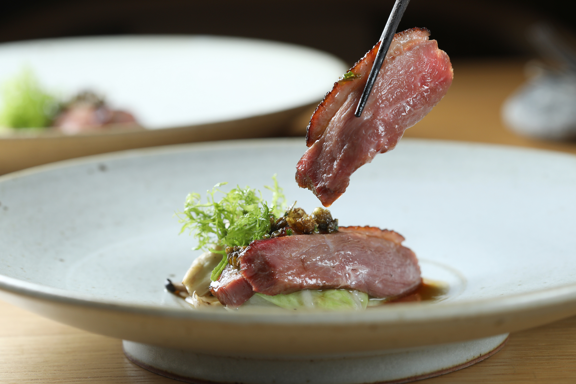「文白鵝 梨山高麗菜 酸豆」將鵝肉煙燻四小時，上桌前烤到酥脆，配上清甜的梨山高麗菜與山茼蒿醬及炸酸豆花。（1,800元／人套餐內容）