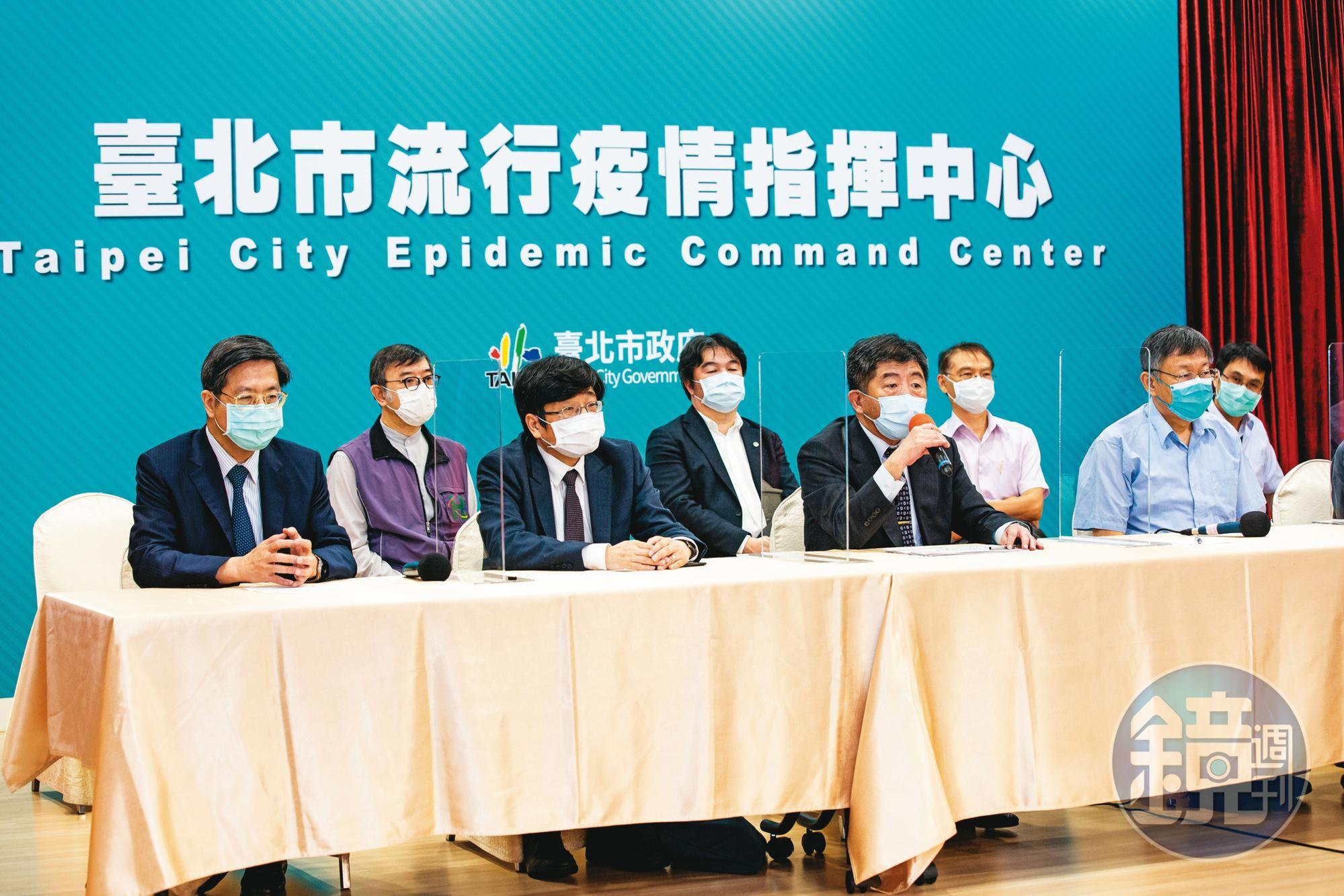陳時中（前排右2）14日率指揮中心官員與台北市長柯文哲（前排右1）合體開記者會，聯手宣布北市率先在感染熱區設立快篩站。