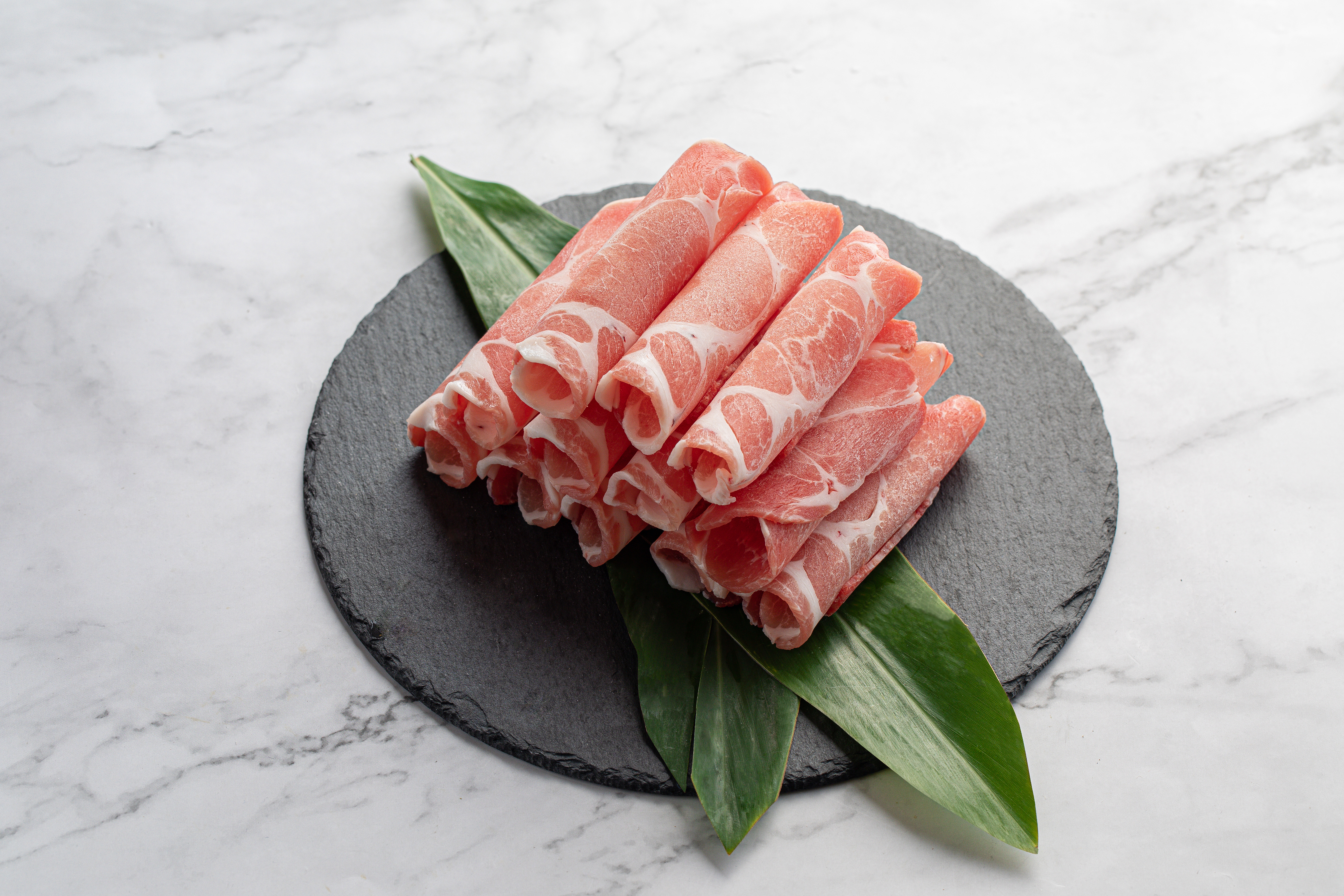 信功曾以冷藏豬肉帶領台灣豬肉出口邁向高峰，其實創立初期，也曾歷經借錢做生意。（梅花火鍋肉片，160元／300克，信功提供）