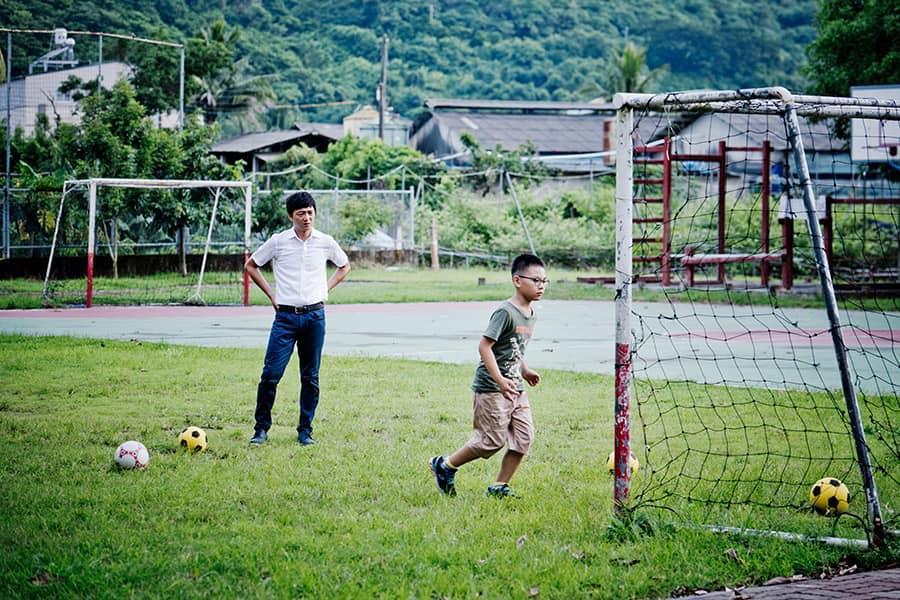 全片的主場景選在高雄阿蓮國小峰山分校，因該校以足球隊著稱，男主角藍葦華（左）也在片中教導童星汪心玨（右）踢足球。（海鵬電影提供）