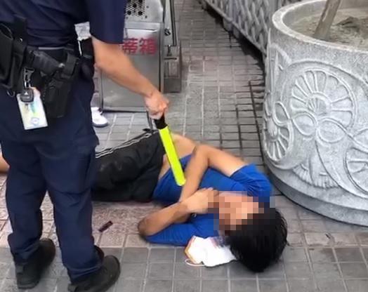 一名倒臥在台北車站附近的男子堅持不肯戴口罩,在警方的勸說下,才願意戴上口罩並離去。(翻攝自爆廢公社公開版)