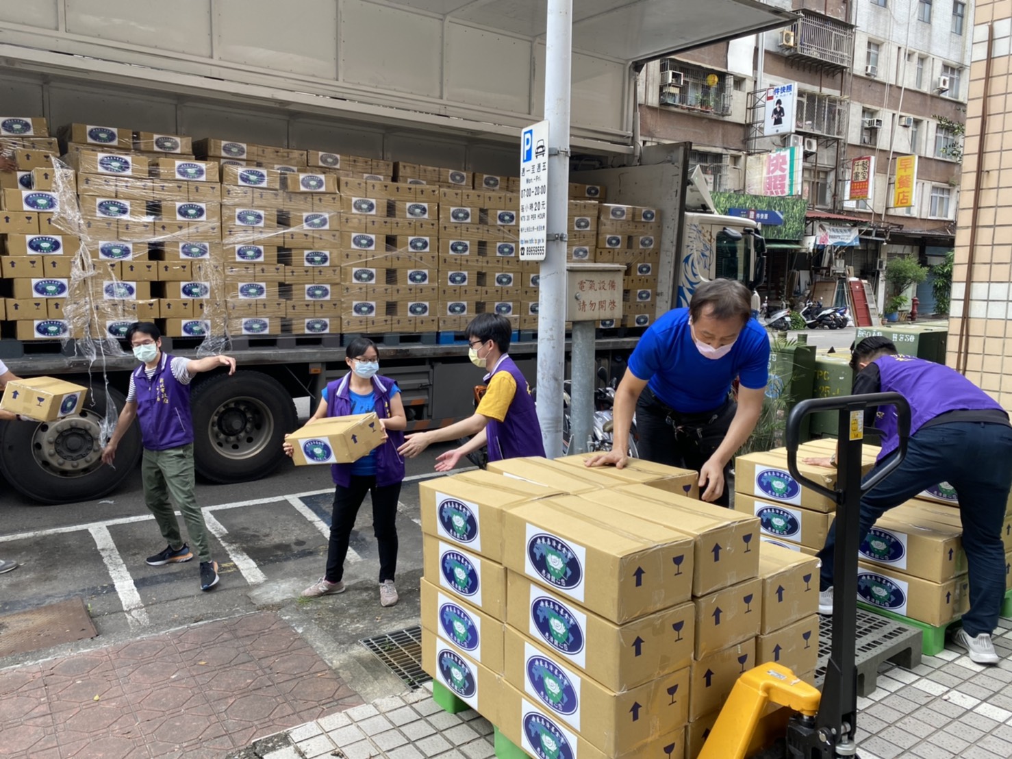 慈濟基金會利用大型運輸車載運食物箱到新北市三重社福中心。（慈善基金會提供）