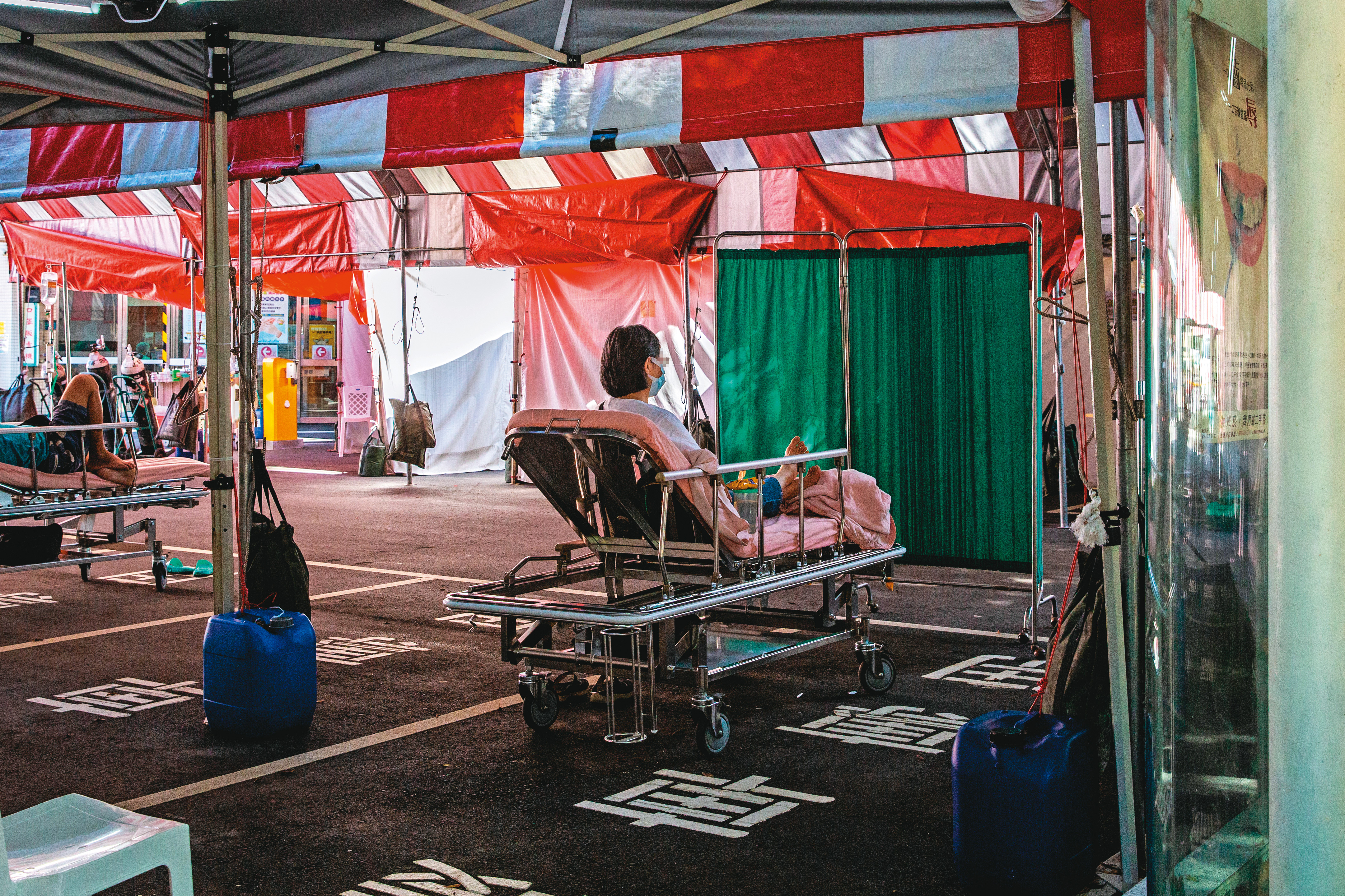 確診病患在醫院的戶外留觀區等待病床。圖為台北市聯合醫院。