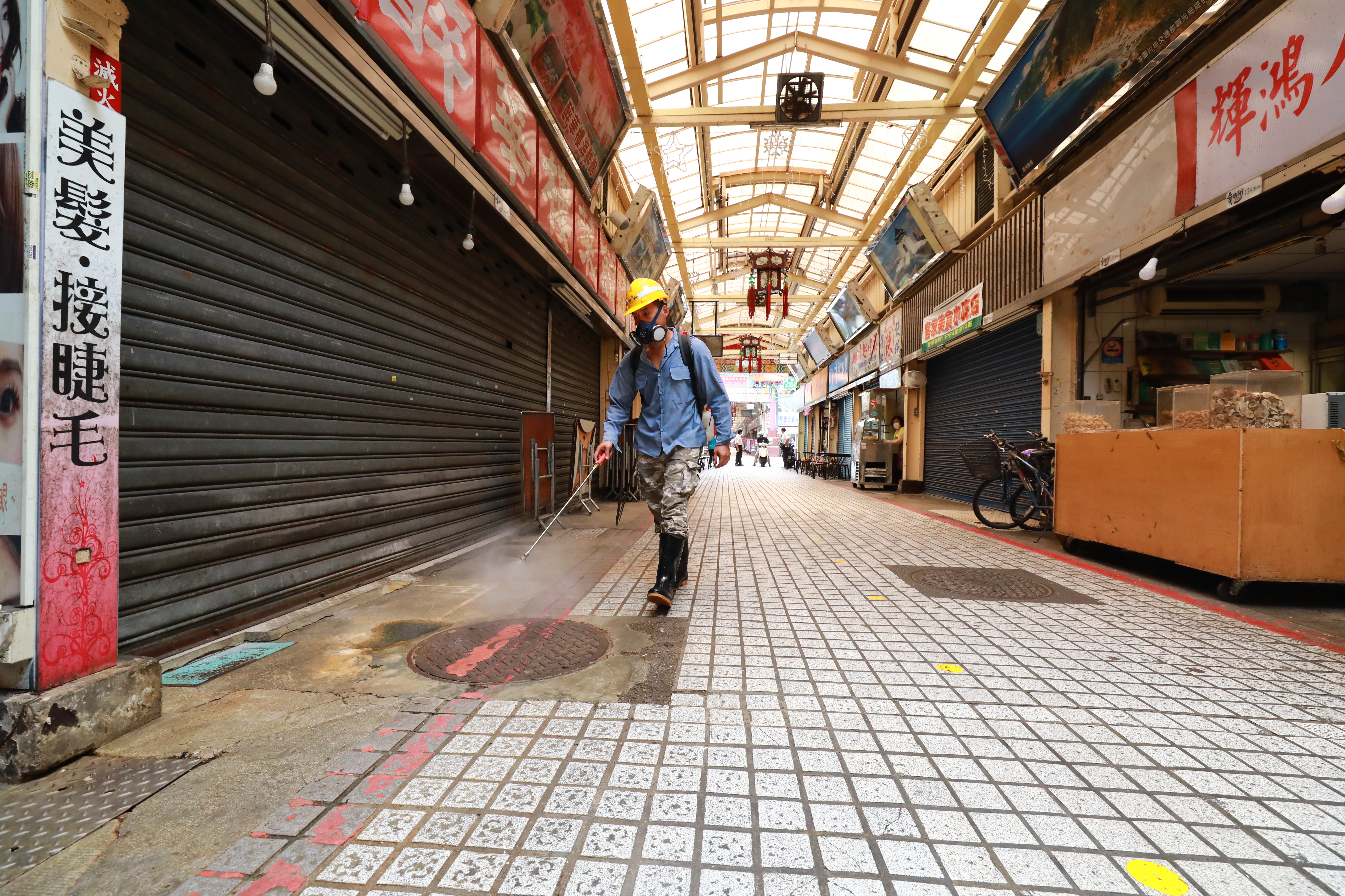 疫情爆發後，身處重災區的華西街觀光夜市少了遊客，只有工作人員忙著進行消毒。