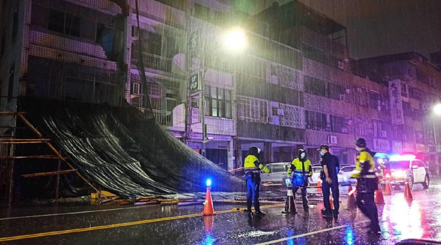 受暴雨襲擊,高雄市區有鷹架倒榻擋住馬路。(翻攝畫面)