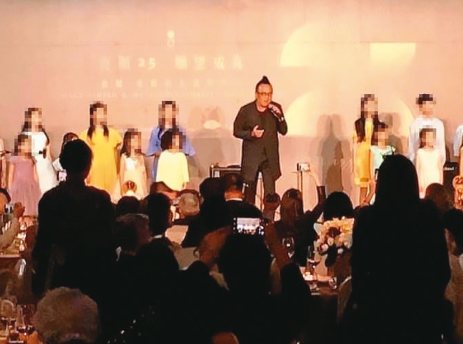 黃大煒（中）受邀出席慈善募款餐會，還上台唱歌與小朋友同樂。（讀者提供）