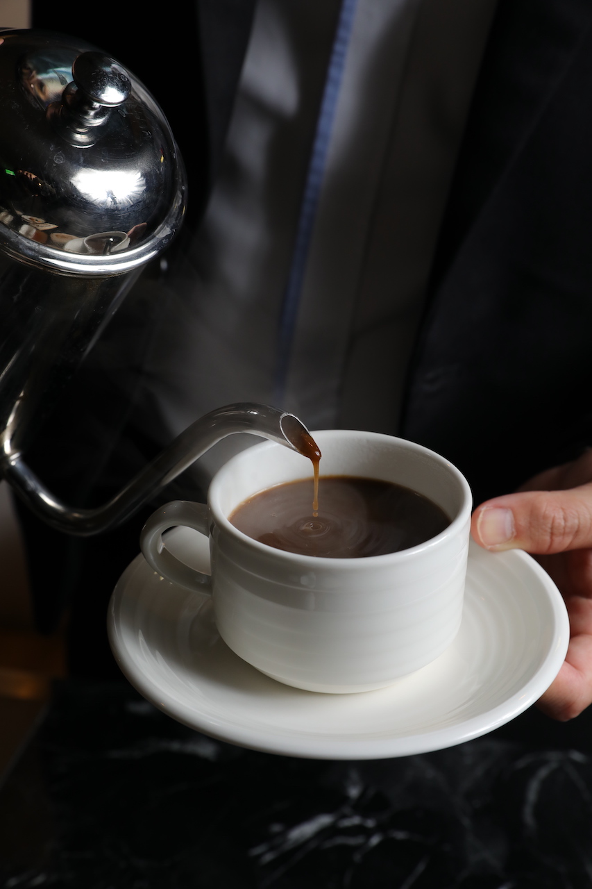 桌邊服務的「黑蒜頭養生湯」，像為客人倒杯黑咖啡。（360元／份）