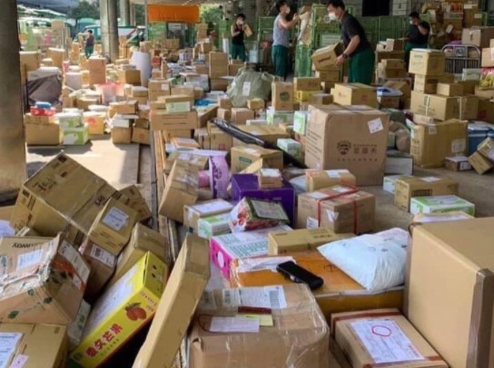 王國材貼出中華郵政照片，員工賣力整理滿地包裹。（翻攝自王國材臉書）