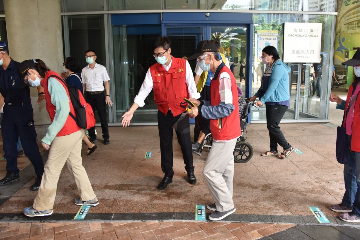 陳其邁一早前往各接種站視察，並協助引導長者排隊接種疫苗。（高雄市府提供）