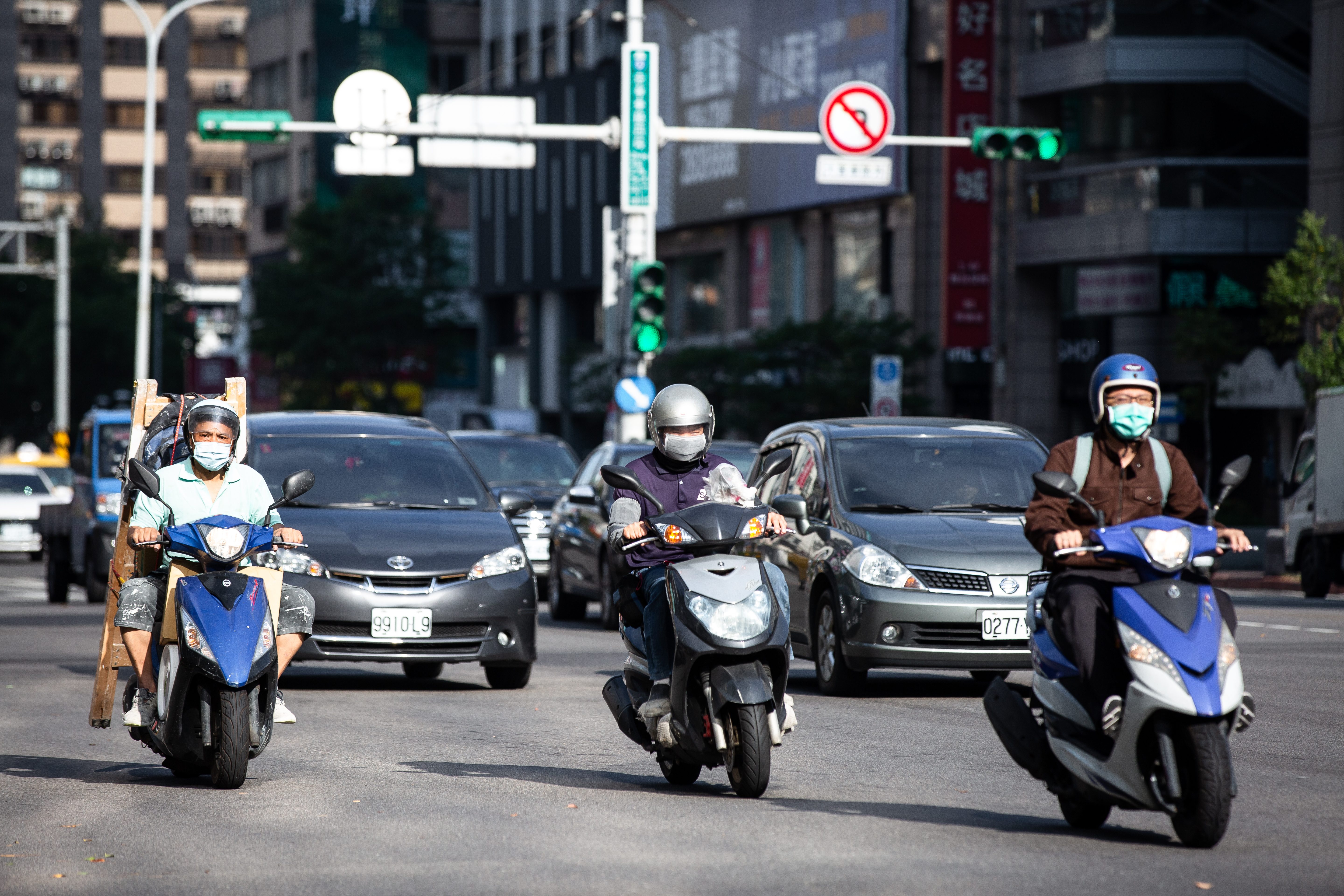 疫情嚴峻,騎車也必須戴口罩,卻有網友抱怨,只是脫罩擦一下臉,就被警察撞見因而開單。示意圖,非當事人。(本刊資料照)