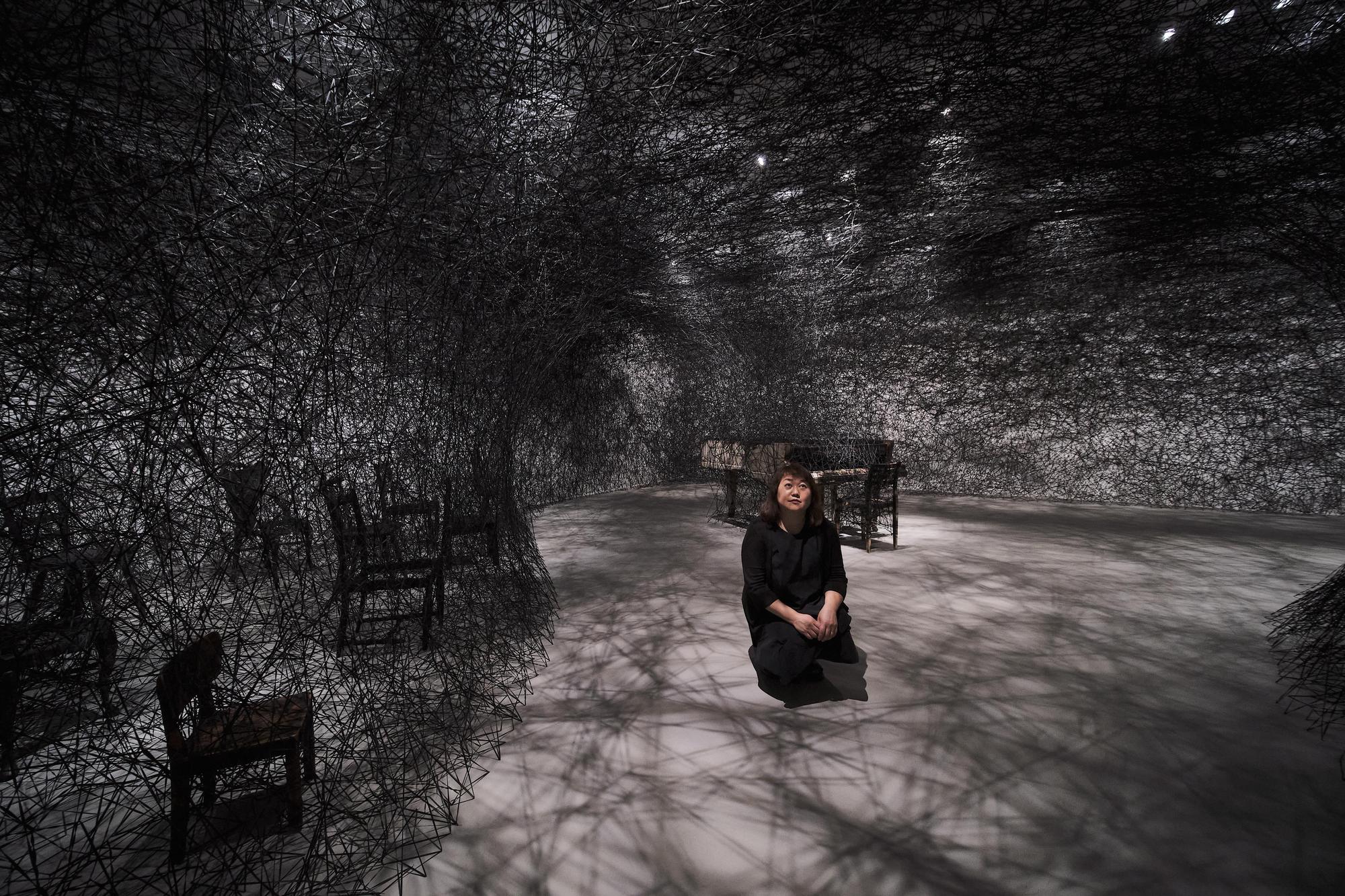 塩田千春4月底特地從柏林飛到台北布展。圖為她以黑色織線、燒焦鋼琴與椅子製作的裝置〈靜默中〉(In Silence)。