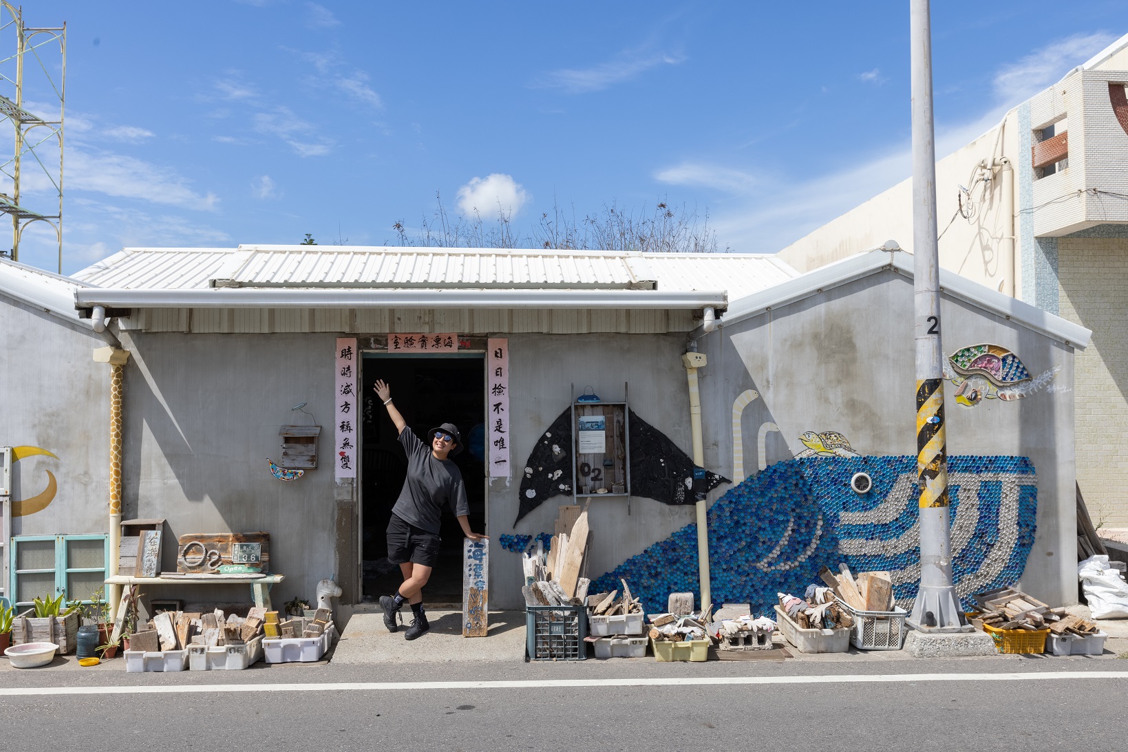 這間小小平房裡承載了海漂廢棄物與人類的自私，外牆也全是由海廢拼成的壁畫。