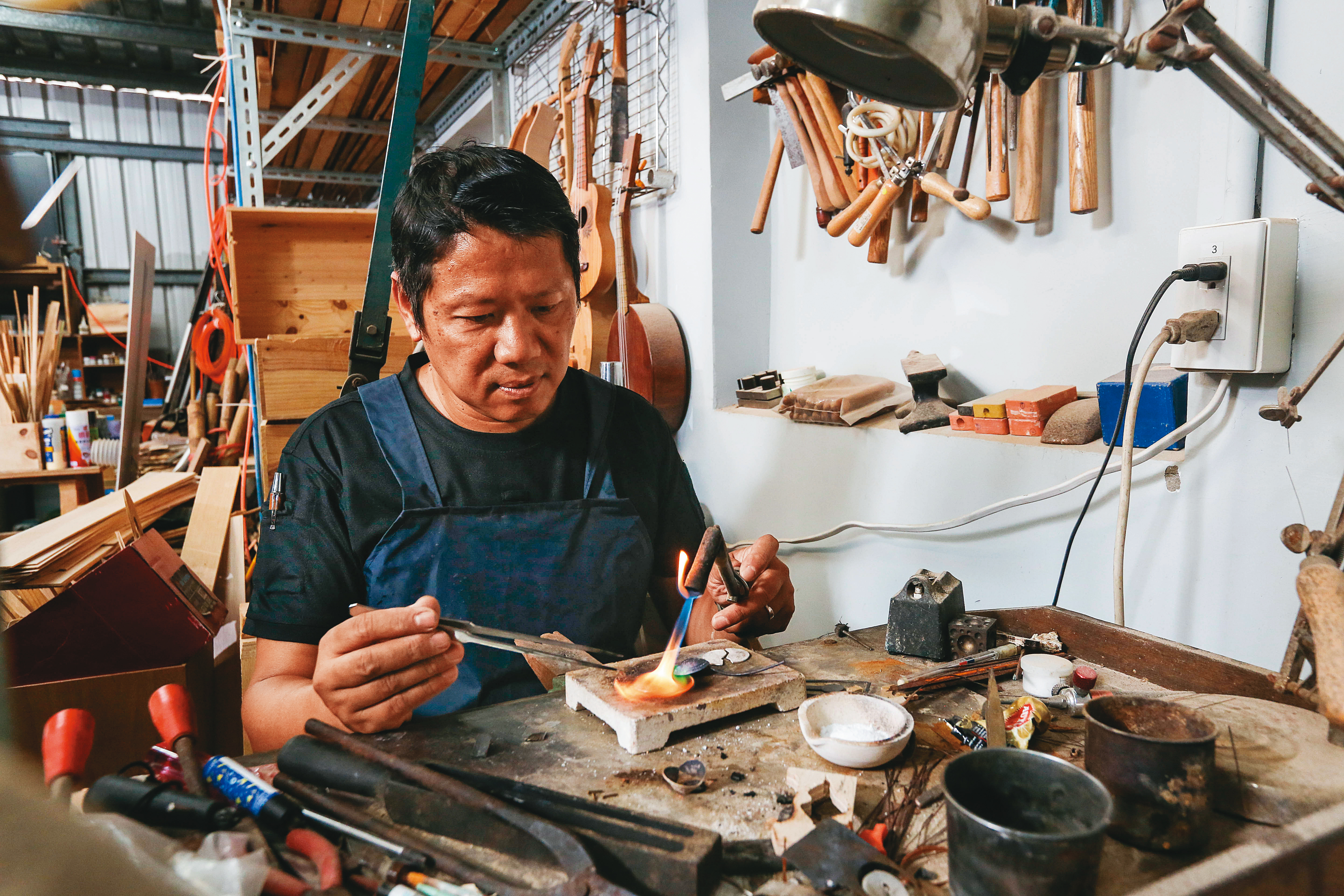 精通金工的溫志榮，也曾創立個人金工工作室。右圖為他親手製作的造舟人剪影黃銅皮帶釦。