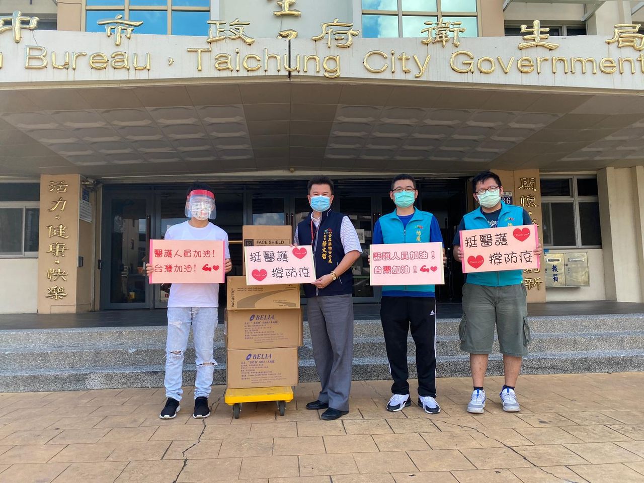 對於辛苦的第一線醫護及防疫人員,郭子乾(左)舉牌「加油」。(翻攝自郭子乾臉書)