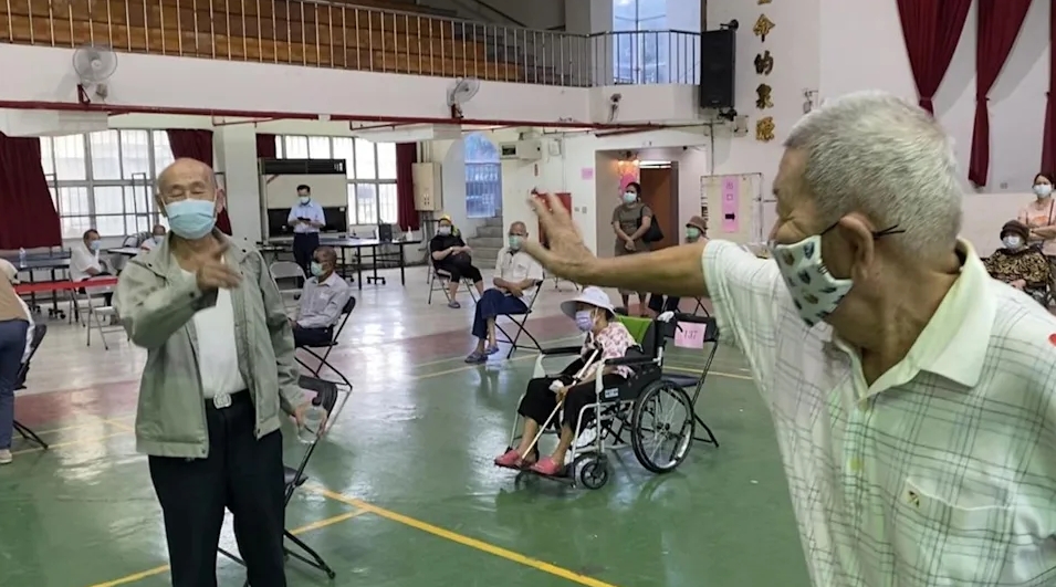 高雄2名同齡阿公接種疫苗巧遇多年不見的「老同學」,開心互虧。(高雄市府提供)