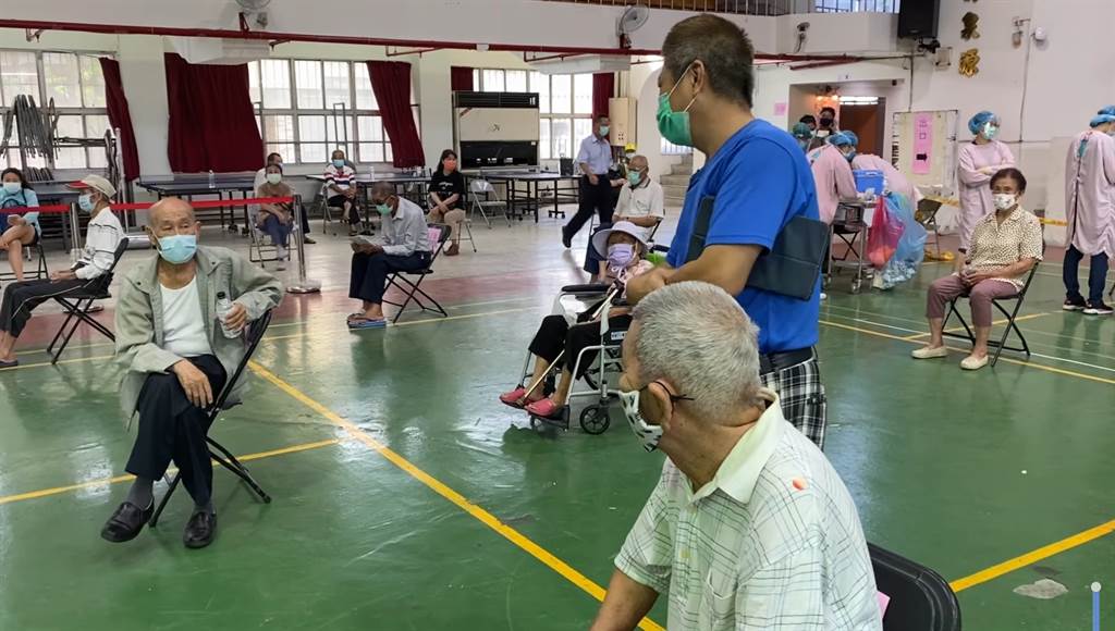 高雄2名同齡阿公接種疫苗巧遇多年不見的「老同學」。(高雄市府提供)