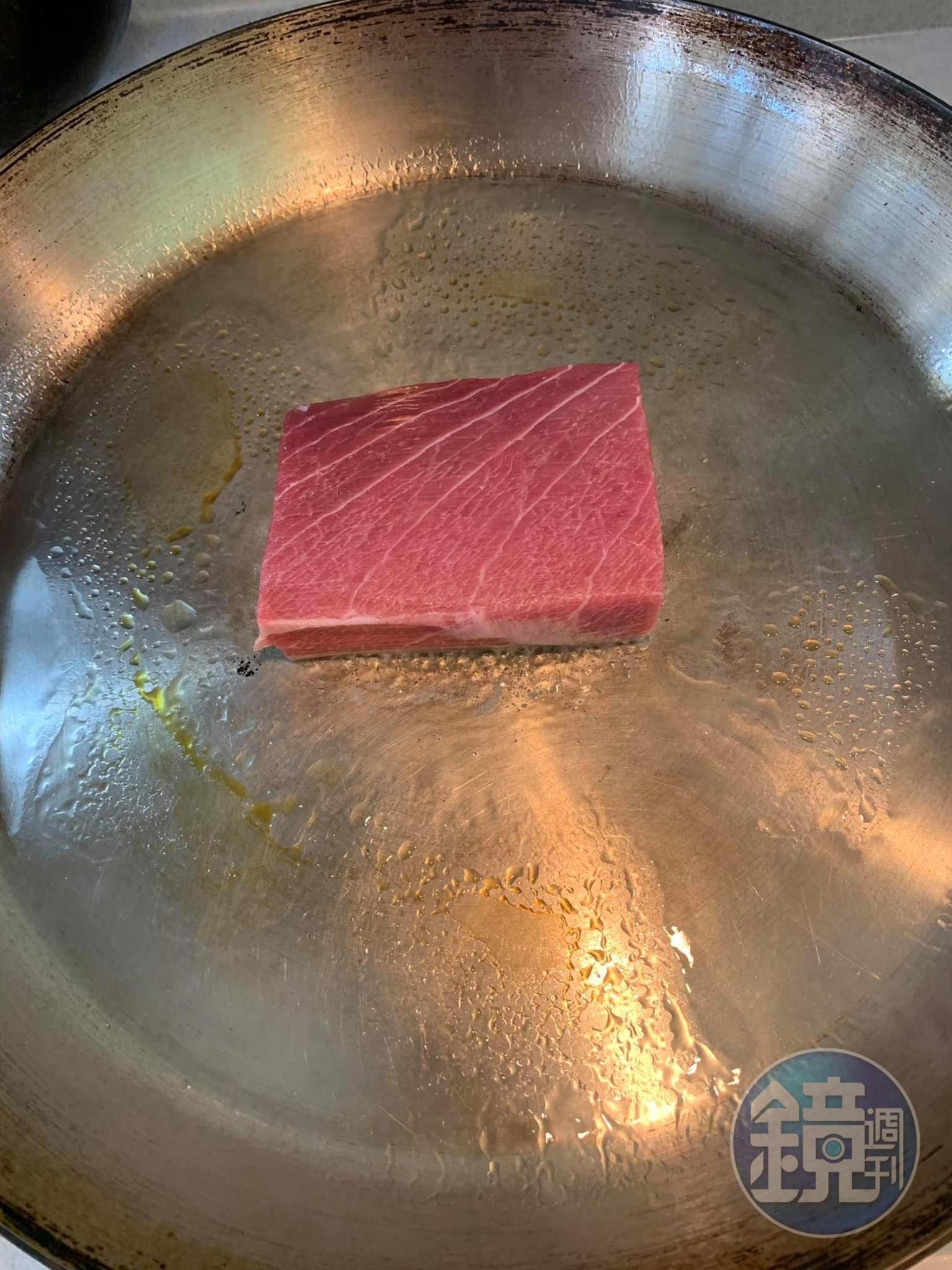 在熱鍋中放入鮪魚排。