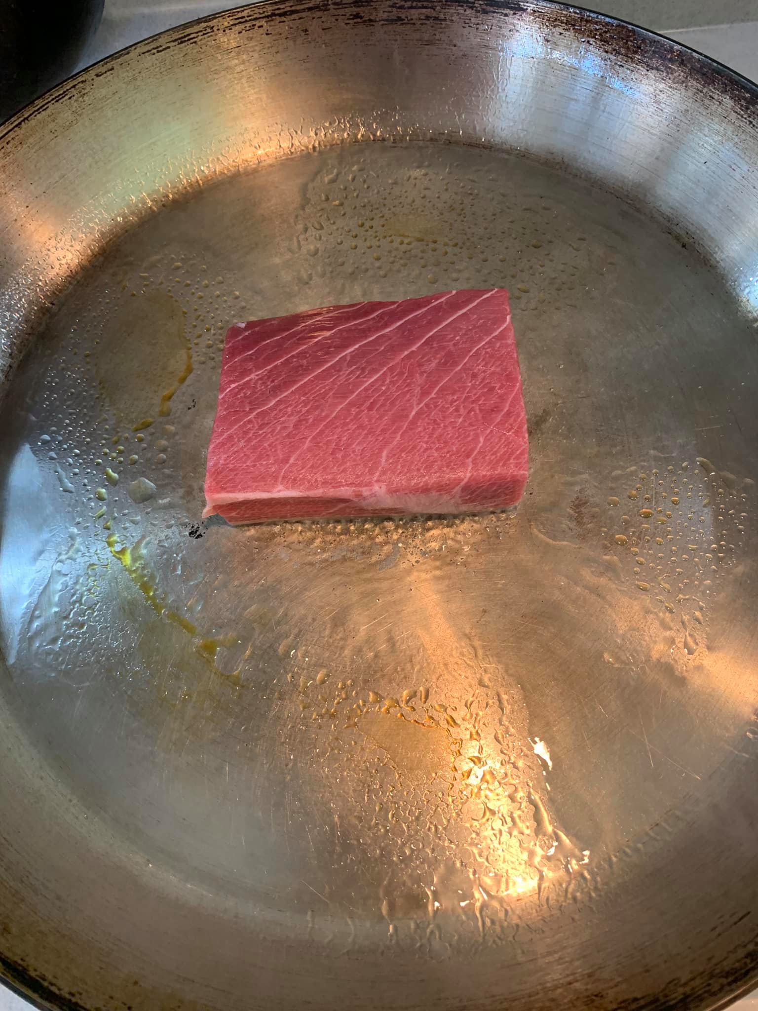 在熱鍋中放入鮪魚排。
