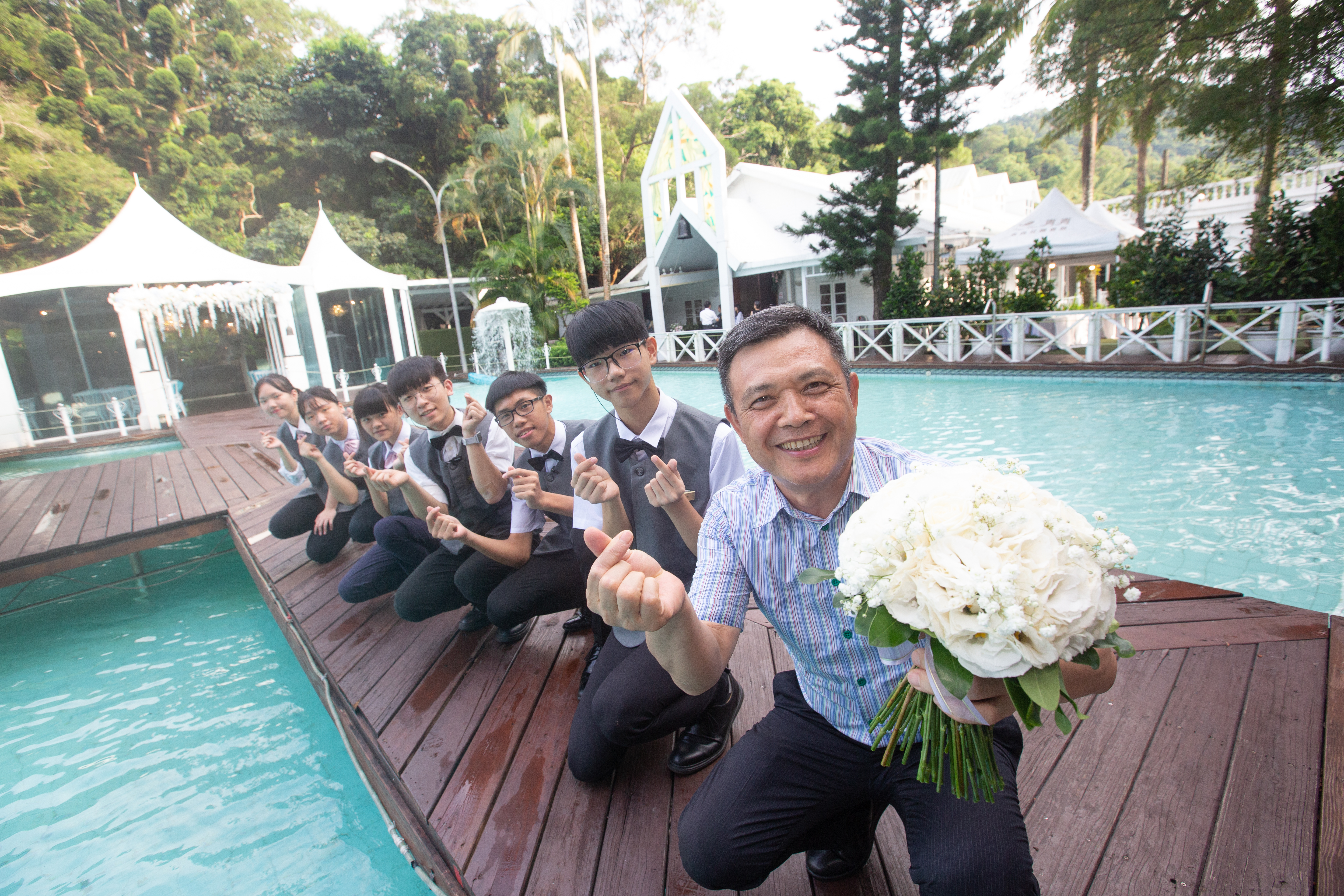 吳永強（拿花者）早年經營餐廳有成，接手台北青青農場後轉型，切入戶外婚宴市場，是國內戶外婚宴龍頭。