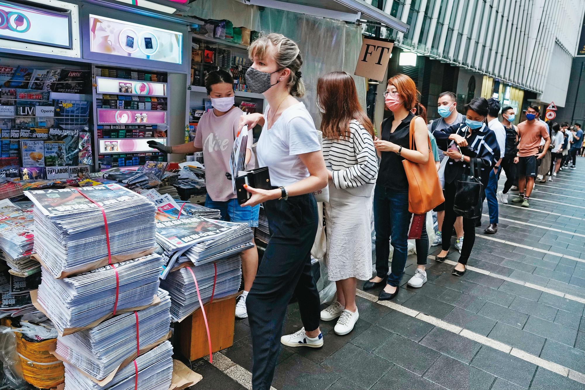 6月24日清早,香港書報攤湧現購買最後一期《蘋果日報》的排隊人潮。(達志影像)