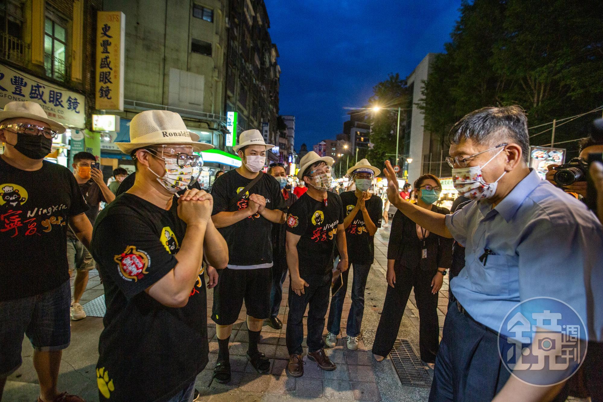 台北市長柯文哲(右)1日晚間親赴寧夏夜市視察「微解封」後的營業情形,為攤商鼓勵打氣。