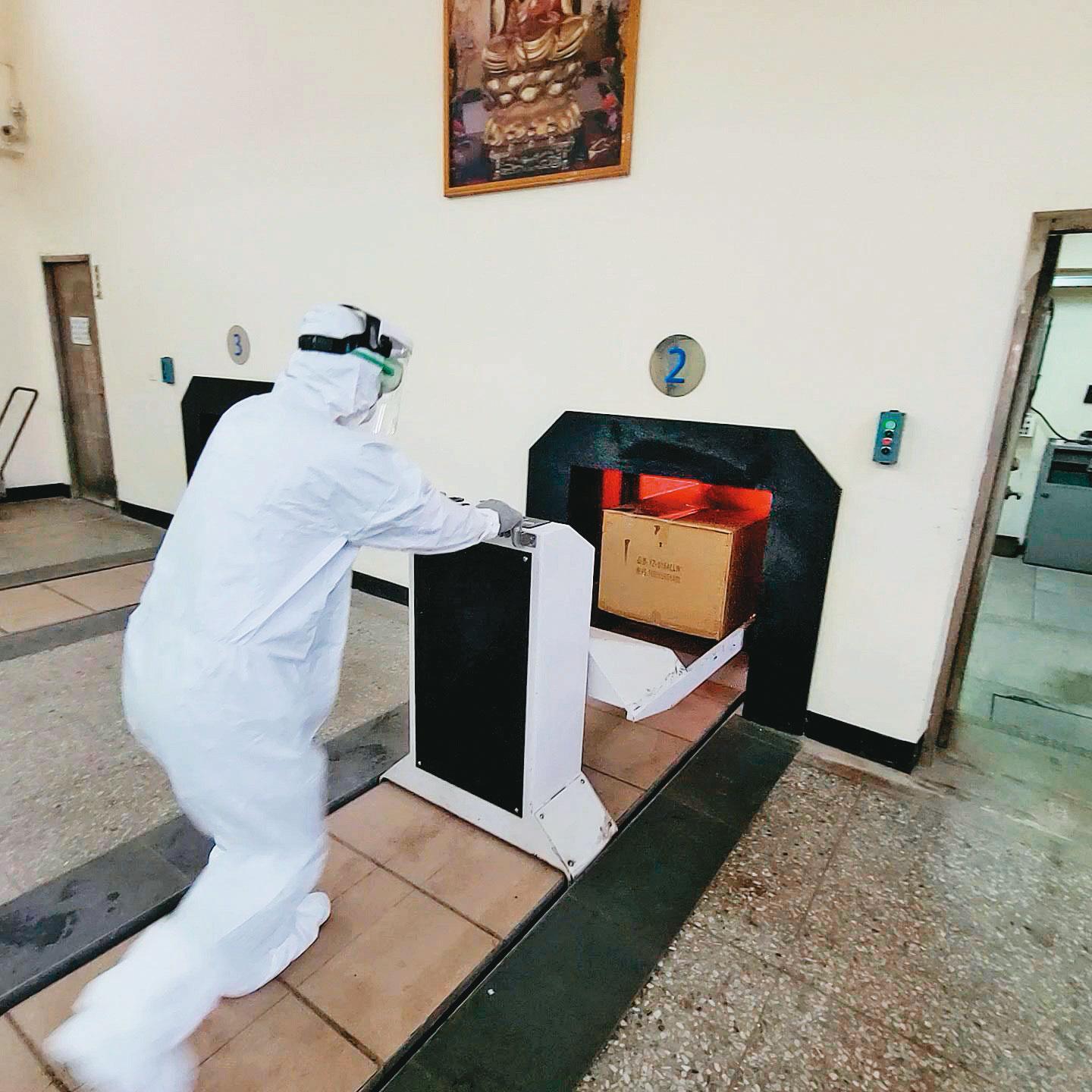  確診大體火化時，工作人員須全程穿戴防護裝備。（讀者提供）